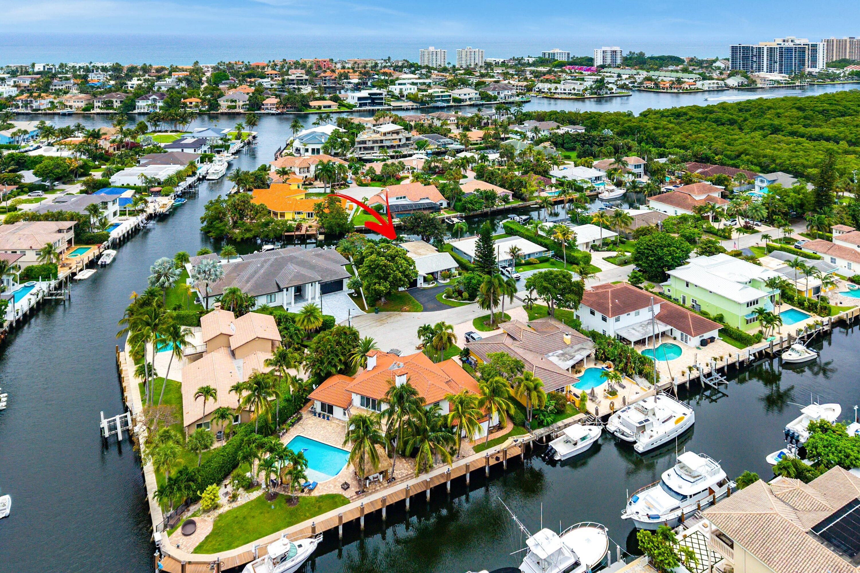 All Boater enthusiasts - Deepwater single story home in Caribbean Keys with 72' of waterfront footage and easy access to the Intracoastal, just 2 canals away and no fixed bridges! This modern residence features an open-concept layout with beamed ceilings in the main living area, and a beautifully renovated interior . Highlights include 24" porcelain tile flooring, all hurricane-impact windows and sliders, LED lighting, and all cast iron plumbing replaced with PVC. Boaters will appreciate the 10,000 lb boat lift (2019), Trex dock (2019), davit and floating docks for jets ski's, remain, and electric in place. Additional updates include a new HVAC condenser (2026), rebuilt HVAC handler and coils (2026), and a new high-efficiency pool pump. Situated on a bonus pie-shaped lot with room to  expand on the north side of the property — ideal for a large garage, artist studio, office, or additional living space. Approx. land dimensions 98 x 106 x 72 x 108