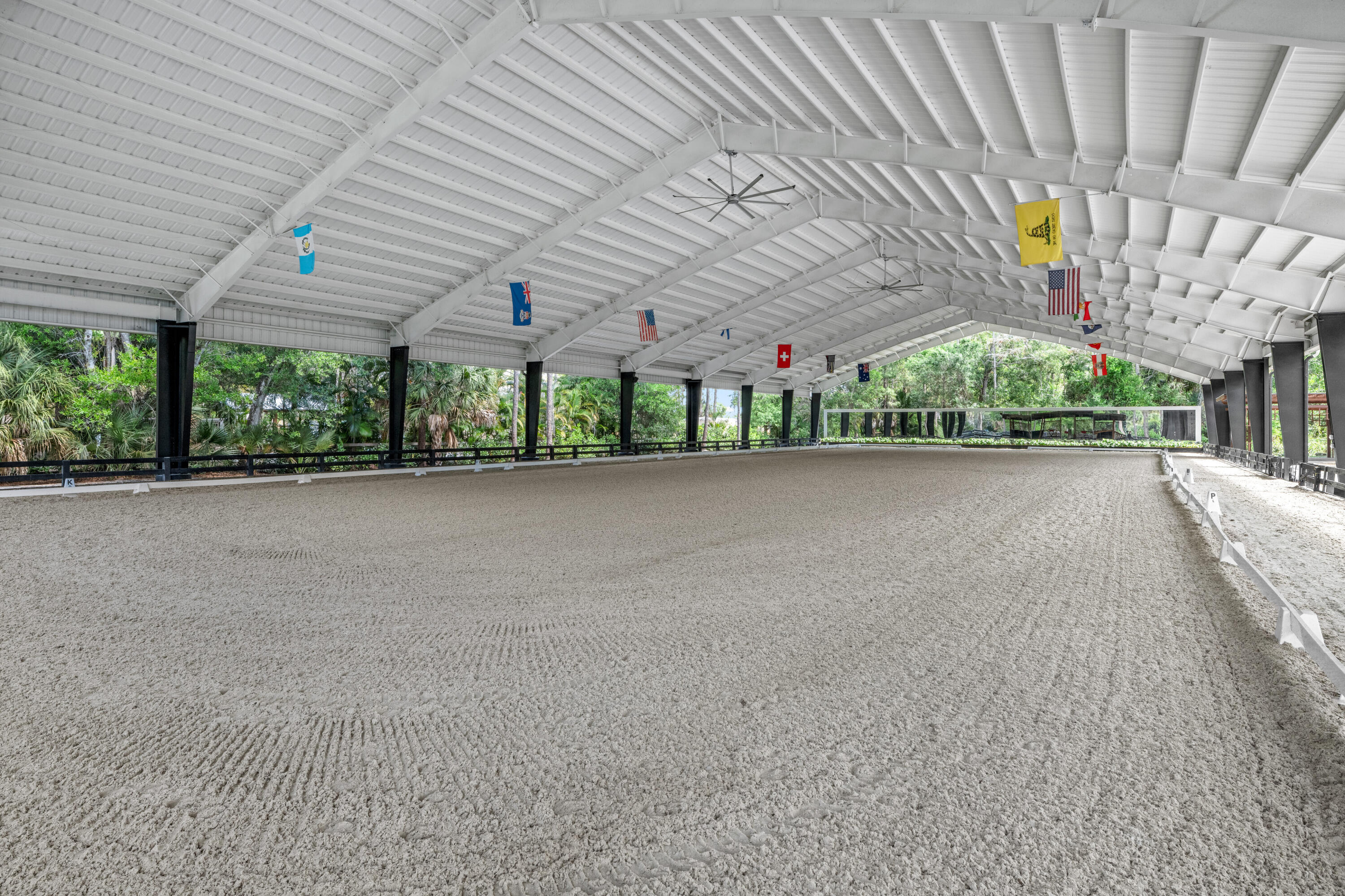 Set beneath a canopy of mature oak trees and just 13 minutes from Wellington International, this exceptional equestrian estate offers a rare blend of top-tier equestrian facilities and refined residential living, all within a private, beautifully landscaped five-acre setting.  The property features two CBS barns totaling 17 stalls, thoughtfully designed with custom stall fronts, elegant chandeliers, and quality finishes throughout—creating a polished yet highly functional environment suited for both professional operations and private use.  At the heart of the farm is a newly constructed 2022 covered arena (98 x 215). The arena is appointed with GGT footing, an advanced Ebb & Flow watering system, custom mirrors, and a spacious viewing area, delivering a consistent and elevated experience Supporting the facility are eight irrigated paddocks, a round pen, tack room with lounge, feed rooms, full bathroom with wood tile accents, laundry, and exceptional groom's quarters, offering a fully equipped, turnkey setup.  The completely remodeled 5-bedroom, 3-bath residence seamlessly blends comfort and style. The chef's kitchen is centered around a dramatic 15-foot island with quartzite countertops, stainless steel appliances, and a wine chiller, ideal for both everyday living and entertaining. The primary suite offers a private retreat with a wood-burning fireplace, an expansive custom walk-in closet with seating area, and a beautifully appointed bath featuring dual vanities, a soaking tub, and a walk-in shower with dual shower heads. A guest ensuite bedroom provides additional comfort and flexibility for visitors.  Outdoor living is equally impressive, with a private, fenced pool terrace finished in travertine with custom turf inlay, creating a clean, architectural aesthetic with a relaxed, resort-style feel. The grounds also feature a pond with a dock and seating area, a fenced dog park, and a gazebo ideal for entertaining or quiet evenings outdoors.  Surrounded by lush landscaping and natural shade, the property offers both privacy and functionality, with a layout ideal for a boutique training operation or private equestrian retreat—just moments from the heart of Wellington's world-class competition venues.