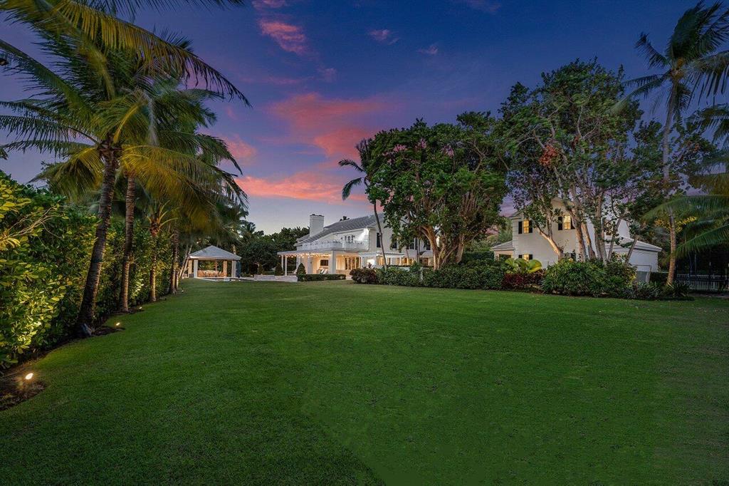 A thrilling and unexpected experience awaits you as you enter this amazing compound located only steps from deeded beach access and Gulf Stream School. Poised on almost one acre, 3432 N. Ocean Blvd. is one of the largest properties in the coveted Gulf Stream core. Offering 4,989 total AC SFT, the home was meticulously reminted in 2017. With five bedrooms, four full baths and one-half bath, the main house features a dramatic two-story entry with a circular staircase and large windows providing loads of natural light throughout. The first floor includes a stunning grand living room with vaulted ceilings and a double-sided fireplace.  Exuding warmth, the family room with finely crafted built-ins and bar, is the perfect place to kick back and enjoy your favorite movie. A privately located office with wall-to-wall library plus an additional office/gym provides a quite space and garden views. Masterfully styled, a spectacular epicurean kitchen reveals top shelf appliances, two dishwashers, oversized island, fine custom cabinetry, Clé tile floors and back splash, wine cooler, ice maker and walk-in pantry. Adjacent to the kitchen is a spacious inviting dining area with floor to ceiling nano doors seamlessly integrating the covered loggia with the interior space. The loggia features cypress ceilings and electric screens with a full outdoor kitchen nearby. Second floor living provides an elegantly styled master suite with beamed ceilings, walk-in closets and a private balcony plus four additional bedrooms. Discover an outdoor oasis with expansive grounds offering swaths of lush green lawn, a pool/spa fit for champion swimmers, and a covered dining pavilion for year round entertaining. Completing the offering is a motor court with four-car garage magnificent guest house with living room, one bedroom, one full bath, and kitchenette with loads of storage. A few additional features include a full house generator, sports court, impact windows, outdoor shower, security system, dog fence, speakers throughout house and garden area. Moments to superb restaurants serving diverse cuisines, and boutique shopping abounds along Atlantic Avenue and Worth Avenue.  A rare offering, this quiet retreat is located close to Delray Beach and all the conveniences for which Palm beach County is famous. Your favorite part of going out will be coming home to your sumptuous estate.