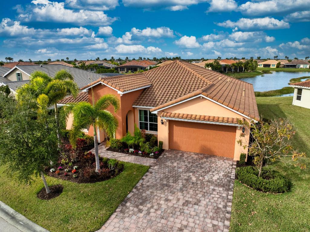 This elegant 4-bedroom, 3-bathroom home with a dedicated den offers over 2,400 square feet of luxurious living space, perfectly designed for comfort and style. From the moment you step inside, you're greeted by breathtaking long lake views that serve as the backdrop to the open family room and stunning kitchen. The kitchen, designed with entertaining in mind, features premium finishes, a large center island, and seamless sightlines to the main living areas. The expansive master suite offers a private retreat, complete with serene lake views, an oversized walk-in closet, dual sinks, and a spa-like stand-up shower. Three spacious guest rooms are strategically positioned for privacy, making them ideal for family or visitors. The den, located at the front of the home, provides a flexible space for an office or creative pursuits. Additional features include impact windows, a durable tile roof, and a brand-new AC unit for peace of mind. The large covered lanai is the perfect spot to relax and take in the stunning lake views, offering a serene outdoor living space. This home is a true gem, blending modern elegance with thoughtful functionality.