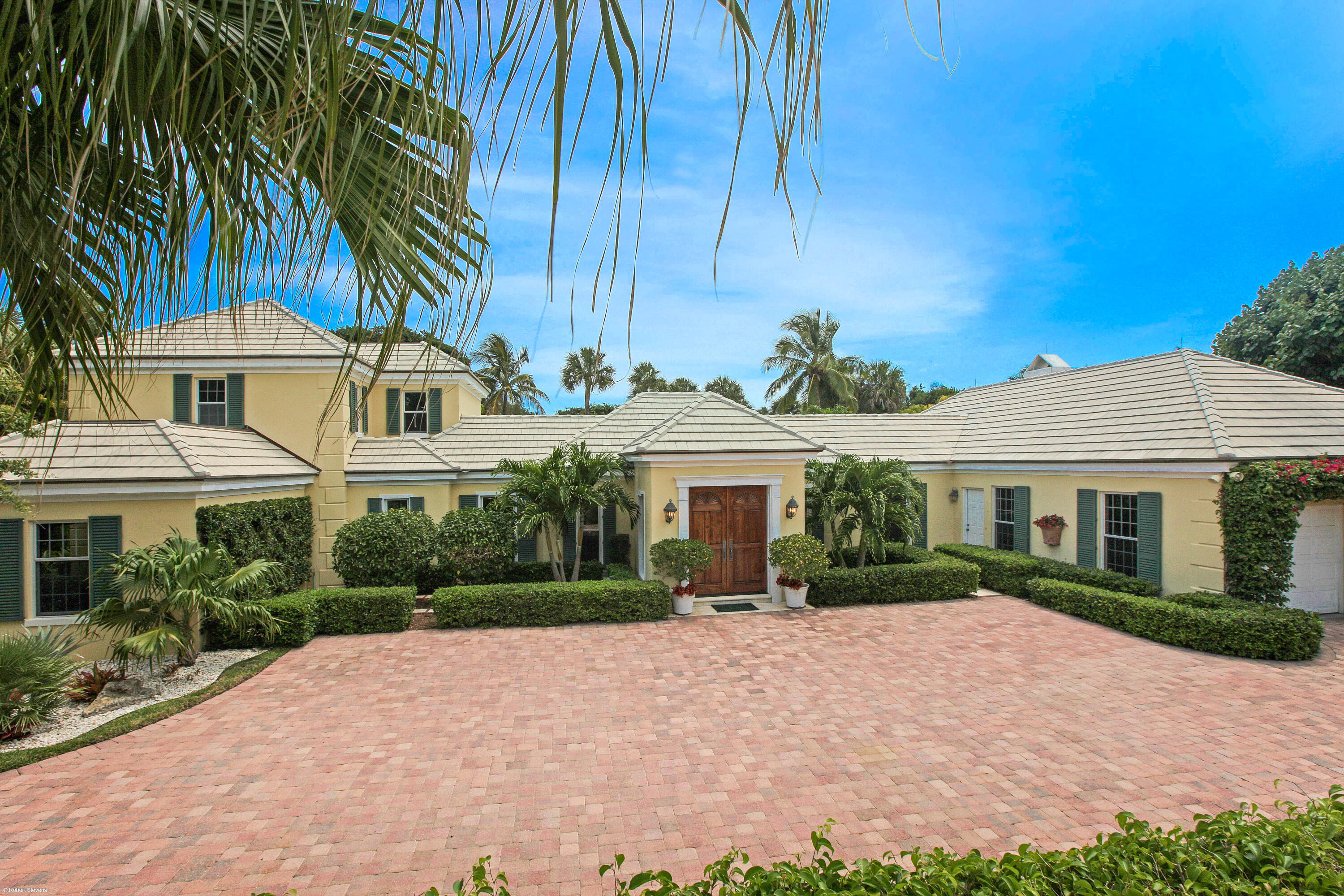 Refined Bermuda-style elegance defines this two-story Jupiter Island residence, ideally positioned in a coveted central island setting. Offering 3 bedrooms and 5.1 baths, the home blends timeless architecture with elevated comfort. A 2-car garage with dedicated separate golf cart storage enhances convenience, while deeded beach access is just moments away. Lush tropical landscaping surrounds a private pool and spa, creating a serene outdoor retreat designed for both relaxation and entertaining. A rare opportunity to experience private luxury in one of Jupiter Island's most desirable locations.