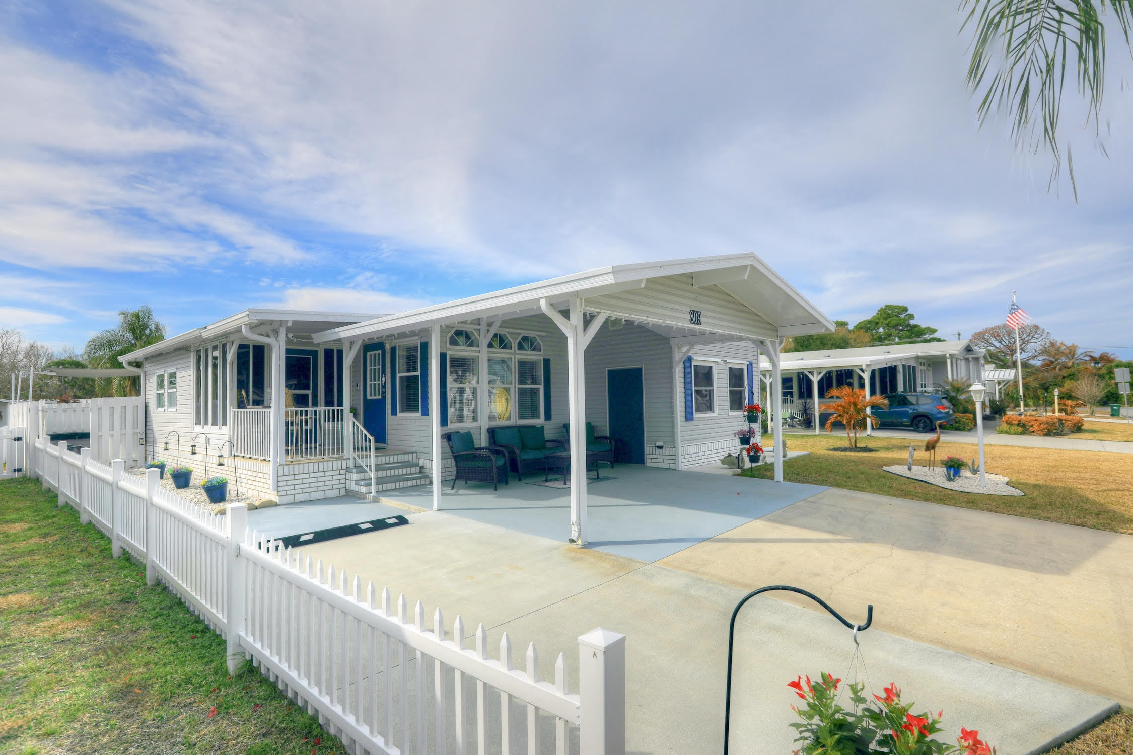 Built in 2003 to updated hurricane specifications, this furnished well-maintained home offers a double carport plus an additional concrete parking pad. Modern kitchen features S/S appliances and a S/S range hood, opening to a spacious great room with sliding doors that lead to a raised, glass-enclosed porch and adjoining paver patio with sail cloth for shade. The desirable split-bedroom floor plan provides added privacy, with French doors opening to the main suite, complete with a walk-in closet and en-suite bath with double sinks. A finished, air-conditioned utility room adds comfort and functionality.