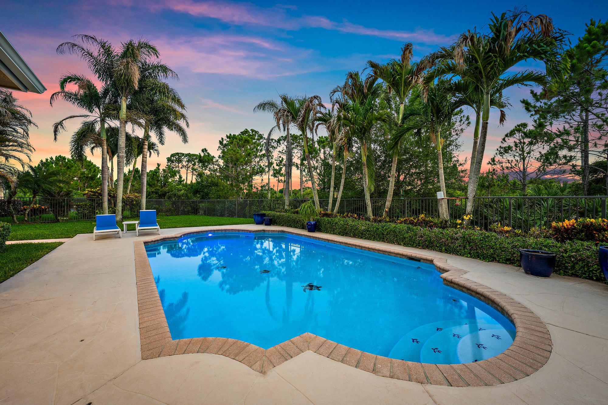 Welcome to The Oaks, one of Hobe Sound's premier gated communities. Nestled on a quiet cul-de-sac within the highly sought-after Estate Section, this spacious four-bedroom pool home offers exceptional privacy, a generous homesite, and serene preserve views. Step inside to soaring ceilings and an abundance of natural light that enhance the formal living and dining rooms. The spacious kitchen is equipped with 42-inch wood cabinetry, granite countertops, a center island, and newer stainless steel appliances. Rich wood flooring flows throughout the main living areas and continues upstairs, adding warmth and character throughout the home. Adding to the home's value and peace of mind, newly installed impact windows and doors provide enhanced storm protection, energy efficiency, and security.  Upstairs, a versatile loft provides additional living space ideal for a media room, home office, or play area.  All four bedrooms are located on the second level, including the oversized primary suite featuring dual walk-in closets and a spacious ensuite bath with separate vanities, a Roman soaking tub, and a walk-in shower.  Additional features include a three-car garage and a fully fenced backyard.  Residents of The Oaks enjoy a low HOA fee that includes lawn maintenance, Xfinity cable and high-speed internet, a community pool and spa, playground, and gated entry, offering both convenience and an exceptional lifestyle.