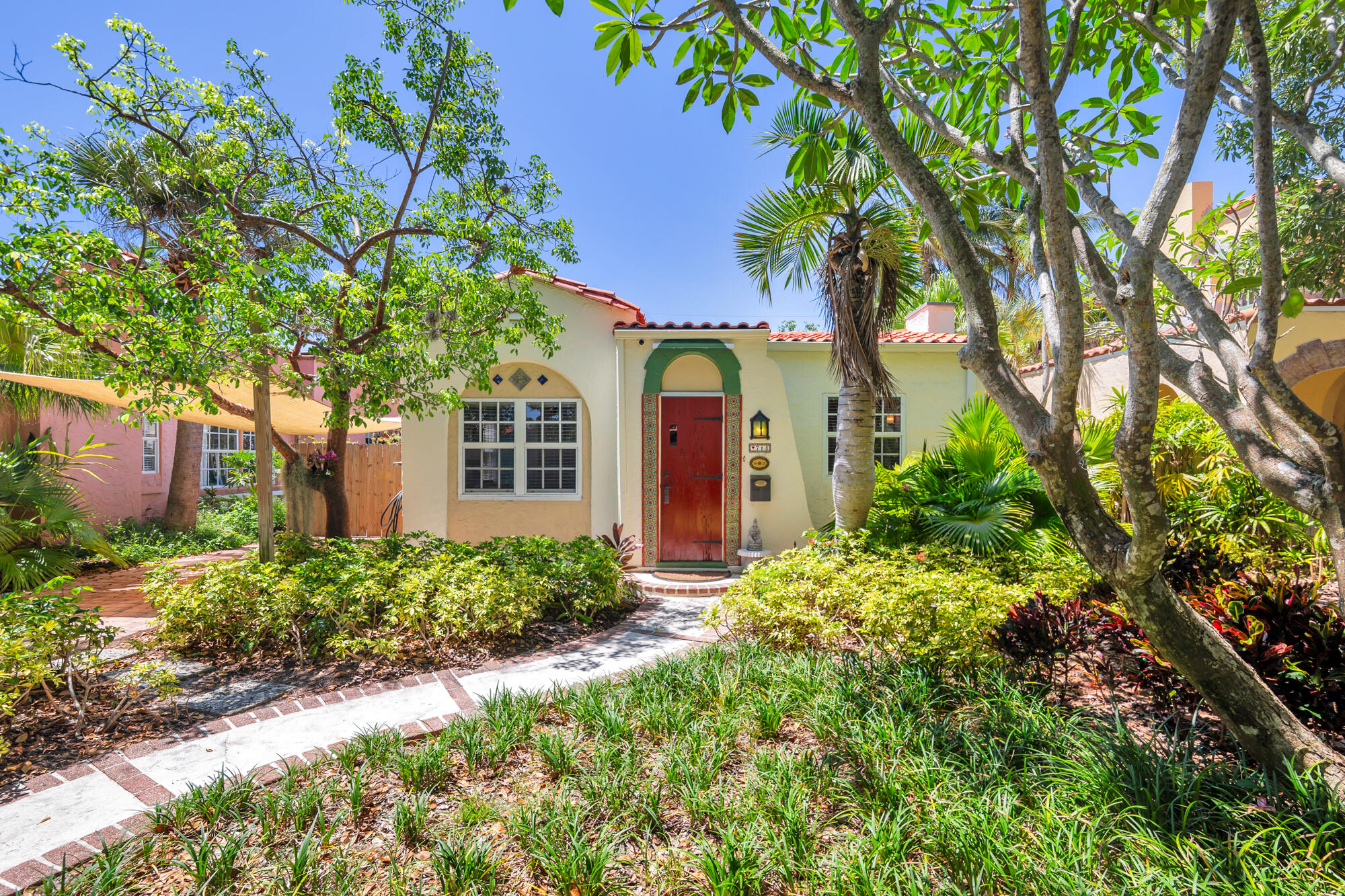 This historic Flamingo Park home was designed by noted architect Hansell Hall. Featuring his signature details, hollow tile construction, barrel tile roofs, mitered hardwood floors, cast stone fireplace, breakfast nook, sunporch, high ceilings, arches, arches & more arches. This 2BR+Den/2BTH home with beautiful guest cottage is situated on a premier tree canopied street on the "Hill Block" of this highly sought-after downtown neighborhood. Beautifully & carefully restored to preserve and showcase the original details of this 1928 gem. Pecky cypress front door, iron light fixtures, French Doors, large light filled rooms all protected by hurricane windows. Large primary suite with walk-in closet, new roof in 2026, solar panels, updated electric & plumbing. Lush mature tropical landscaping.
