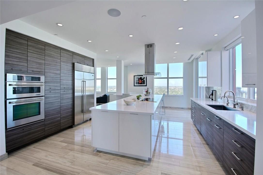 Stunning contemporary Penthouse on the sand with incredible ocean to downtown views.  Huge combined open air and covered terrace that wraps almost 180 degrees around the unit. Perfect for the entertainer with massive cook's island and eat-in kitchen, large formal dining with seating for 14 and custom bar--all with views from east to west.  Modern split floorplan with his and hers master baths and closets, large laundry and separate den area,  Marble plank flooring and more.  Must see!