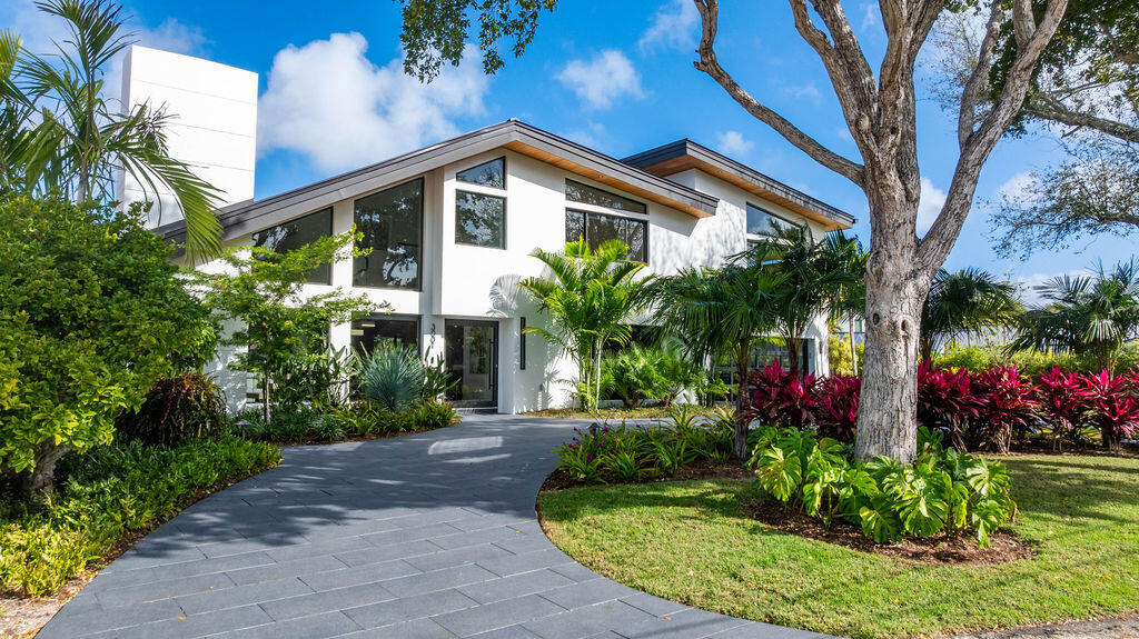 Absolutely stunning mid-century modern waterfront home in a desirable Lighthouse Point enclave with 81.6 feet of waterfront. Completely rebuilt by discerning owners with no expense spared, featuring exceptional high-end finishes throughout. Custom cabinetry and premium natural stone surfaces complement a fully integrated smart home with hard-wired shades, lighting, audio, video, and security. Marine-grade white oak flooring offers the beauty of real wood with superior durability. Porcelain driveway and backyard add to the home's sleek design. Enjoy a covered lanai and summer kitchen overlooking a wide basin offering rare privacy. Completely updated seawall with integrated retaining wall, polymer dock and a 33K-lb boat lift complete this exceptional property.