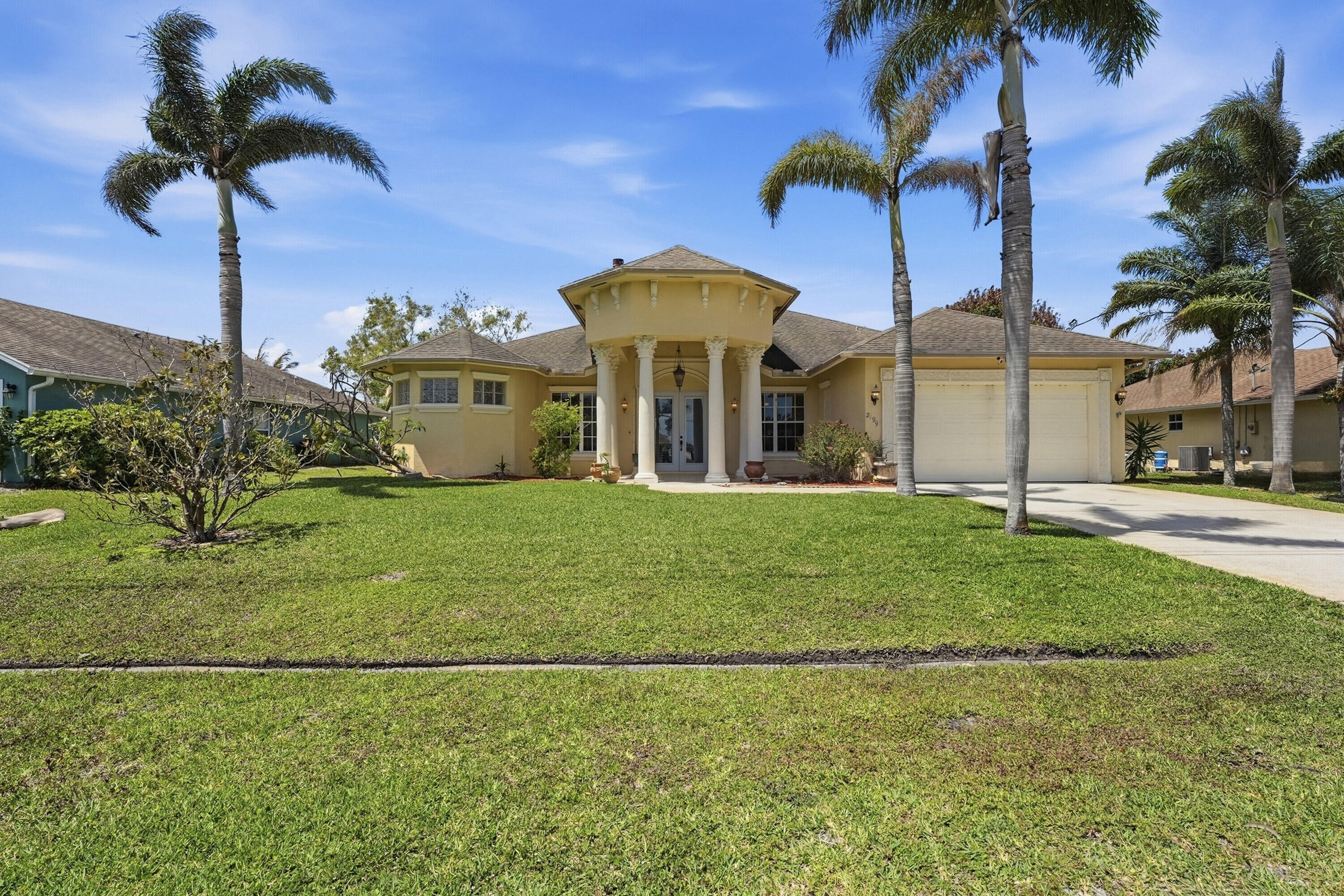 East of US-1 canal-front Vanderhoff home close to Jensen Beach, beaches, hospitals, and shopping. This 4BR/3BA/2-car garage offers 2,432 sq ft under air with a spacious split floor plan. Features include a fireplace, triple tray ceilings, and crown molding throughout. The upgraded kitchen has granite countertops, custom cabinetry, gas range, built-in oven and microwave, and large pantry. The primary suite includes a sitting area and spa-style bath with soaking tub, dual sinks, and walk-through shower. Formal living, dining, and family rooms open to a covered screened lanai with summer kitchen overlooking the canal and fenced backyard.