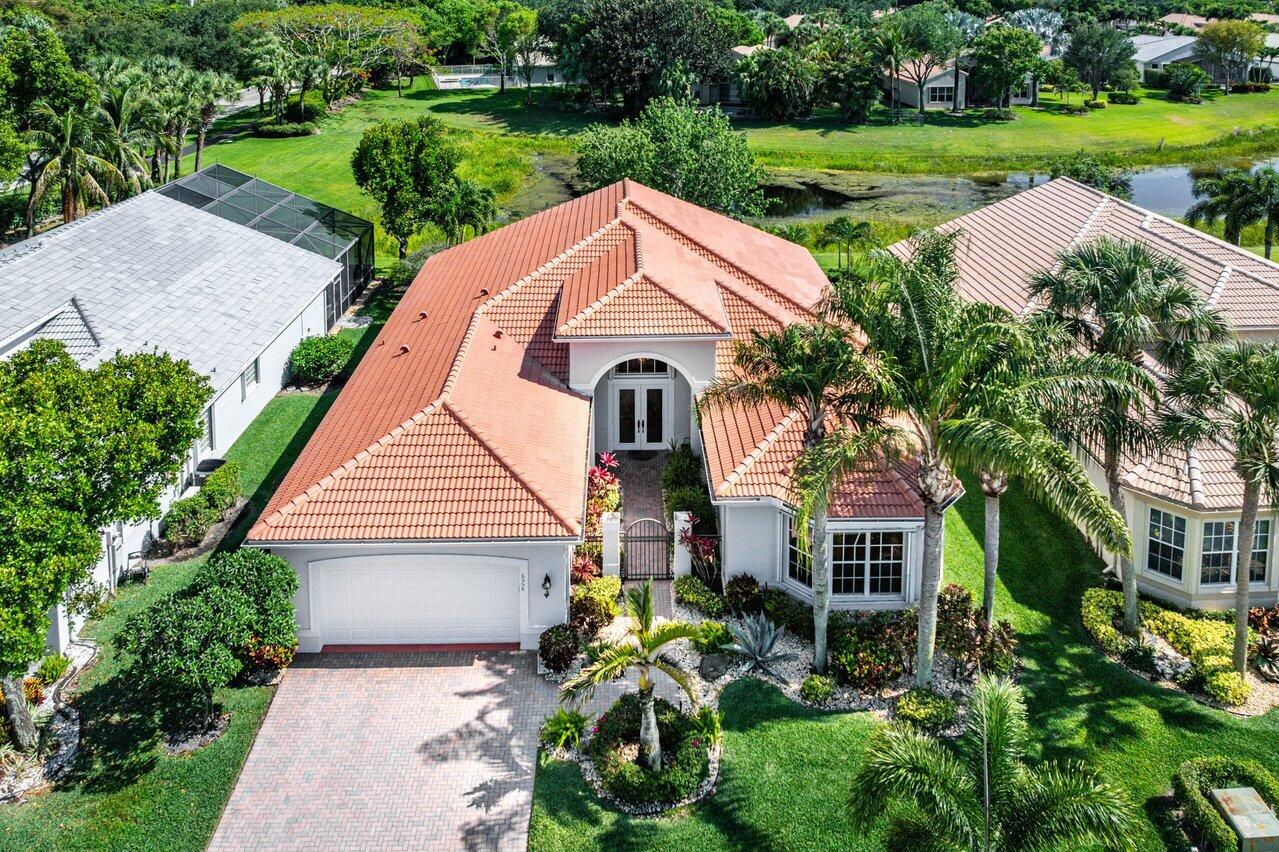 Stunning lakefront 3 BD, 2.5 BA residence in Valencia Palms of Delray Beach, offering timeless elegance and beautifully maintained finishes that can be enjoyed as is or thoughtfully reimagined to suit a more contemporary style. Designed for both comfort and entertaining, the kitchen opens seamlessly to the living room and a charming breakfast room framed by angular bay windows overlooking the tranquil lake. The living room is spacious with a grand built-in entertainment center, and is complemented by sliding glass doors leading to the patio. This expansive screened and covered patio extends from the living area, creating the perfect setting to enjoy the peaceful outdoors year-round.  Surrounded by lush greenery and wetland-inspired flora, the landscape unfolds in quiet harmony as the Florida sun glistens across the lake, sending a gentle sparkle dancing across the water's surface. The expansive primary suite captures stunning lake views and features two oversized walk-in closets, along with a spacious primary bath, perfect for personalizing into a spa-like retreat. Additional highlights include a bright en-suite guest bedroom, a dedicated office that can be converted to a third bedroom, and a walk-in laundry room for added convenience. Located within Valencia Palms, a gated active adult community known for its resort-style lifestyle, residents enjoy access to a 31,000-square-foot clubhouse, a fitness center, resort-style pools, tennis and pickleball courts, social clubs, and a vibrant calendar of activities, all just minutes from downtown Delray Beach dining, shopping, and beaches. This home also features a new roof (2025), and 2 new AC units (2024).