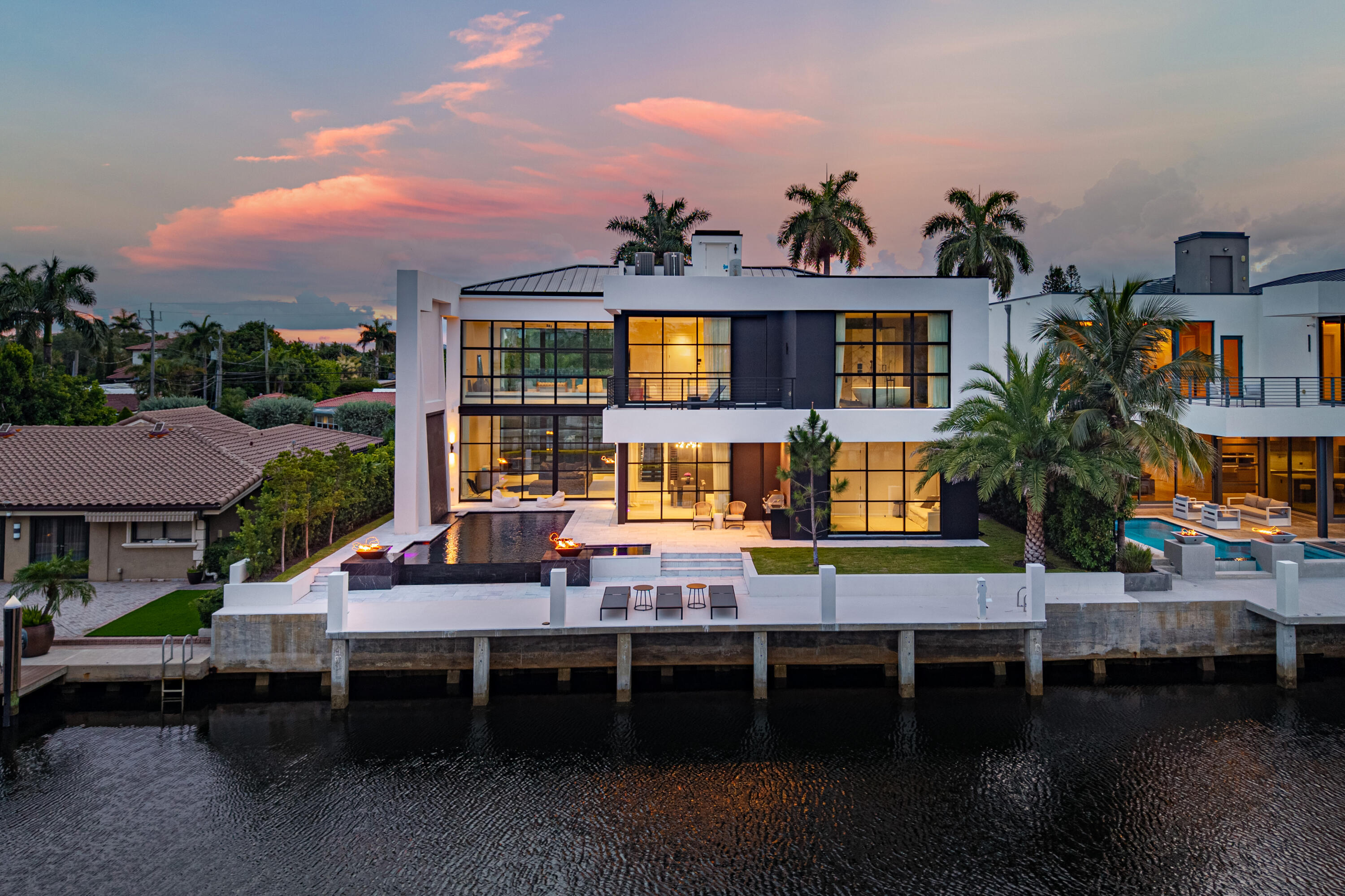 Brand-new waterfront construction in the heart of Lauderdale-by-the-Sea, offering direct ocean access with private dockage just minutes by boat to the Intracoastal Waterway and Atlantic Ocean. Developed by Bricker, this exceptional residence features 4 bedrooms, 4 full baths, 2 powder rooms, a private office/studio, and a private elevator. Spanning 4,446 square feet under air and 5,718 total square feet, including the garage, the home is thoughtfully designed across two levels.  A dramatic pivot entry door opens to an impressive light-filled great room with soaring 23-foot open-to-below ceilings and walls of impact-rated glass that frame stunning waterfront views. The open-concept living space flows seamlessly into a chef's kitchen appointed with Wolf and Sub-Zero appliances,  including a 48-inch refrigerator, induction cooktop, wine cooler, ice maker, and a dedicated coffee pantry. Expansive sliding glass doors lead to the covered lanai, complete with a summer kitchen featuring a built-in gas grill.  Designed for effortless indoor-outdoor living, the backyard showcases a resort-style infinity-edge pool with a waterfall edge, sculptural sloped water wall, dual gas fire bowls, an outdoor shower, and a poolside powder room with convenient access from both the interior and exterior. The first floor also features a guest suite with an en-suite bath, an additional powder room, a private office/studio, and a spacious laundry room.  Upstairs, the luxurious primary suite offers a private waterfront balcony, dual vanities, separate water closets, spacious dressing closets, and a spa-inspired bath. Two additional bedrooms each feature en-suite baths, while a spacious game room loft with a wet bar, sink, refrigerator, and dishwasher opens to a second waterfront balcony overlooking the canal, creating the perfect setting for entertaining.  Additional highlights include natural gas service, impact-resistant windows and doors throughout, a two-car garage with lift capability, premium designer finishes, and exceptional craftsmanship. Ideally located just steps from the beach in one of South Florida's most sought-after coastal communities, this extraordinary residence delivers the ultimate South Florida waterfront lifestyle.