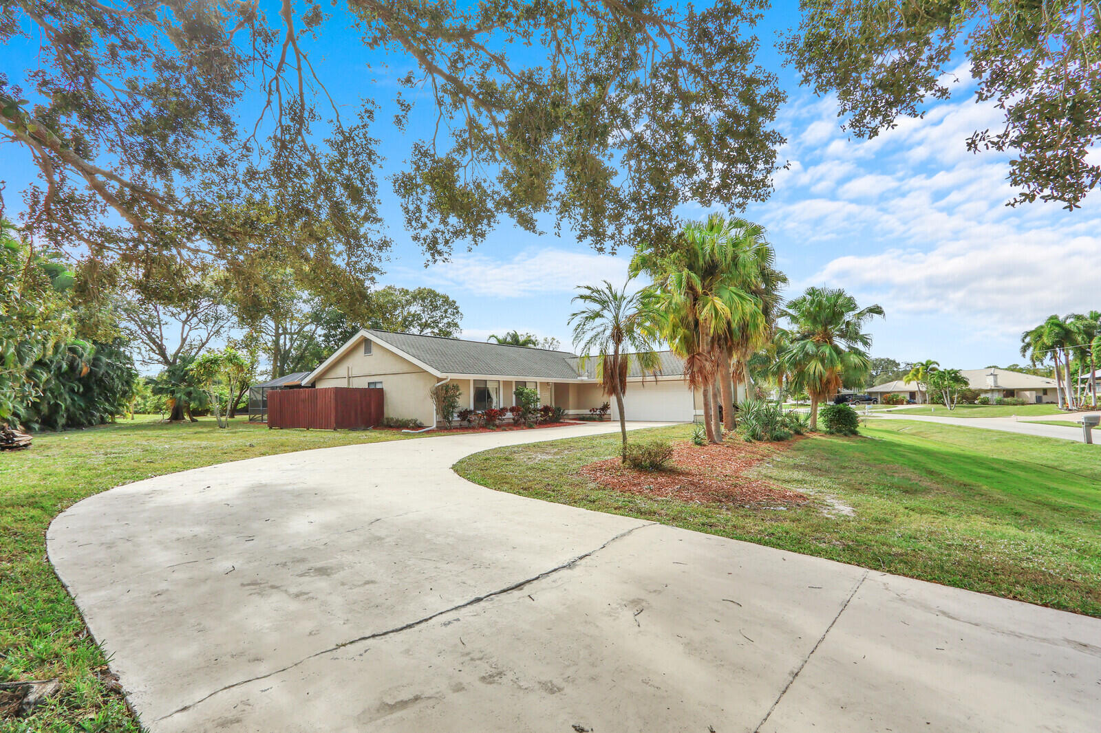 Opportunities to own a pool home on a HALF-ACRE lot in Port St. Lucie are increasingly rare, especially in the heart of coveted Sandpiper Bay! With no HOA, this property offers exceptional space, privacy, and endless possibilities for outdoor living, future enhancements, discreet storage for a boat or RV, or simply the luxury of elbow room. The beautifully renovated interior is designed for effortless living and comfortable entertaining. Natural light pours through wide French doors, illuminating the open great room and enhancing the home's bright, connected layout. Anchoring the space is a crisp white kitchen featuring granite countertops, a generous center island, Frigidaire stainless steel appliances, deep drawers, and bar seating that easily transitions from casual mornings to relaxed gatherings. The spacious living area opens to a screened lanai with a crystal-blue pool and covered patio, creating an inviting extension of the home that can be enjoyed year-round. A flexible den with an ensuite bath and private entrance offers excellent versatility as a home office, flex space, or small guest suite. The owner's suite provides a comfortable retreat with double closets and a beautifully renovated bath featuring dual sinks and a frameless tile-surround shower with a built-in bench.  An attractive scalloped architectural shingle roof adds both durability and character. Ideally located just minutes from riverfront parks, golf, dining, and area beaches, this property delivers privacy, land, and style without HOA fees or restrictions. Offered at $600,000, the renovations, pool, half-acre homesite, zero HOA, and move-in-ready condition set this property apart from the rest of the market.