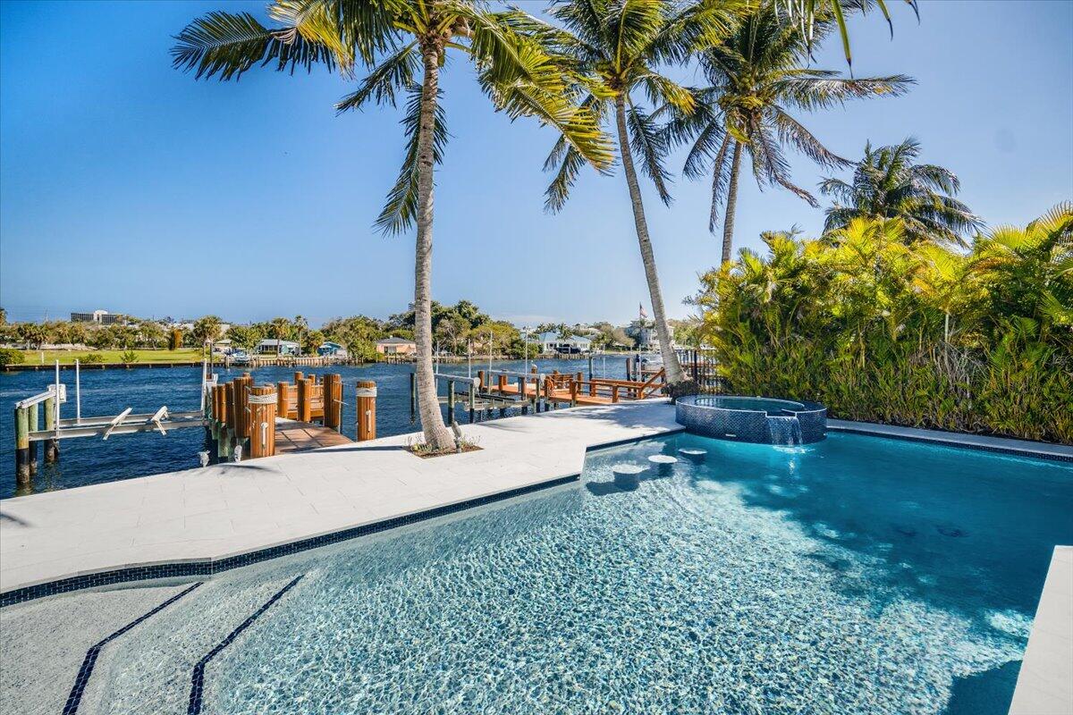 You will love everything about this property! This direct intracoastal home completely reimagined in 2024 is ready for you this season. Located in a boutique gated community, this is a boater's dream complete with private dock, 20,000 lb lift and direct ocean access with no fixed bridges, just minutes to the Palm Beach inlet. Elevated palm beach chic design paired with Downsview custom kitchen, top-tier Wolf and Sub-Zero appliances, including an integrated Wolf espresso machine. Wake up to sunrises over the water & unwind in your spa-like bath with a freestanding Roman tub, large walk-in shower, and Toto Washlet. Designed for seamless outdoor-indoor living with massive sliders opening to your outdoor retreat with marble hardscape, refinished saltwater pool with a new heater, and many lounging spaces to enjoy the boats cruising by. Outfitted with a gas fireplace, impact windows, Lutron lighting system, and a BRAND NEW ROOF! Nothing left to do but move in & enjoy!
