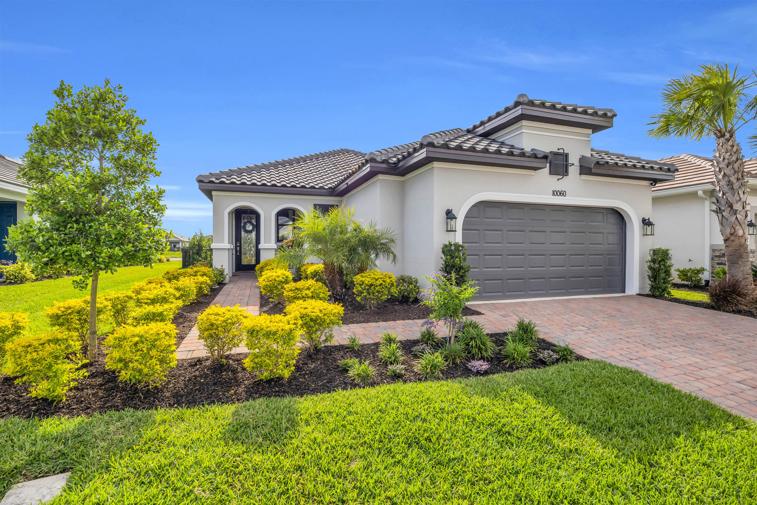 Fall in love with this Lakefront Bergamo Beauty! 10060 SW Santini is MOVE-IN READY NOW and is highly upgraded! This spacious beauty offers 2 large bedrooms plus flex-room and is centrally located on a street that has no more construction on a lake-front, fenced lot! Receive peace of mind with friendly neighbors, fenced yard and cameras. This beauty was built in 2024 & feels like a model! UPGRADES INCLUDE: Impact windows & custom front door, Whole-Home HVAC U/V Filtration system, custom chandeliers, designer curtains & remote control black-out blinds, tinted glass for privacy, beautiful wallpaper, built-in closet shelving, shower water filtration, tankless water heater, gas stove, Samsung refrigerator w/ interchangeable panels, epoxy garage floor and Clearview patio screening. MOVE IN!