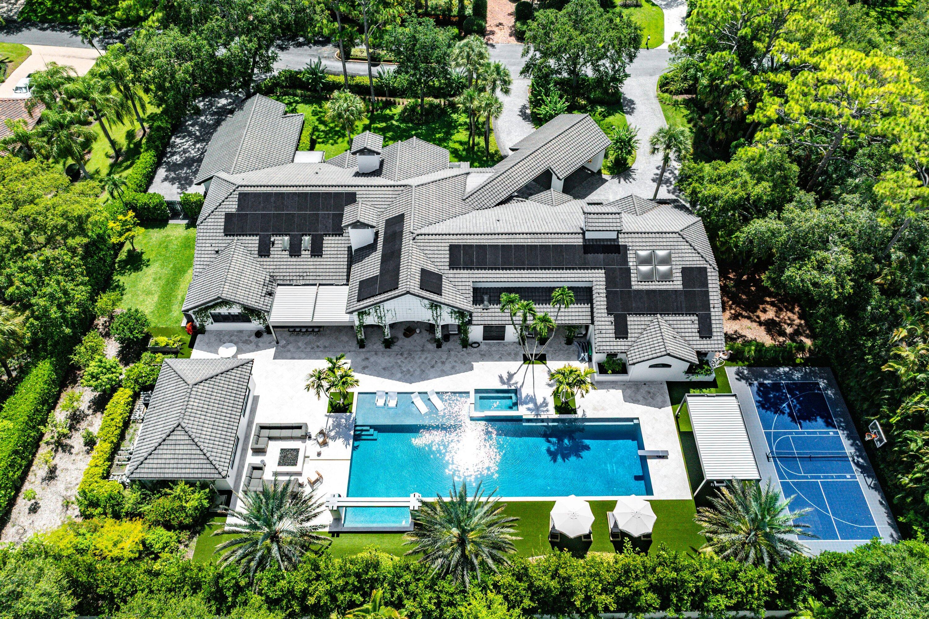 Experience resort-style living in this recently renovated, private gated one-acre estate located in one of Delray Beach's most exclusive communities, offering just 43 homes and an unbeatable central location. Designed for both luxury and entertaining, this exceptional residence delivers an unparalleled lifestyle with expansive indoor and outdoor living spaces. Step outside to your own private resort featuring a spectacular 70-foot pool, spa, cold plunge, outdoor shower, fire pit, dramatic fire bowls, expansive summer kitchen, oversized loggia for outdoor dining and relaxation, pickleball court, basketball court, butterfly garden, and beautifully landscaped grounds. The thoughtfully designed floor plan features 4 bedrooms plus a private office, dedicated gym, theater room, music jam room,  and an additional private office adjoining the primary suite. Wide-plank white oak flooring, natural gas, public water, and premium finishes throughout elevate every space. The home is also equipped with two refrigerators, two dishwashers, and two full-size washer and dryer sets for ultimate convenience. Additional highlights include a three-car garage, impressive circular driveway with porte-cochère, living plant wall, and complete privacy throughout the lush one-acre property. Please note: The detached guest house is not included in the lease. No pets permitted.
