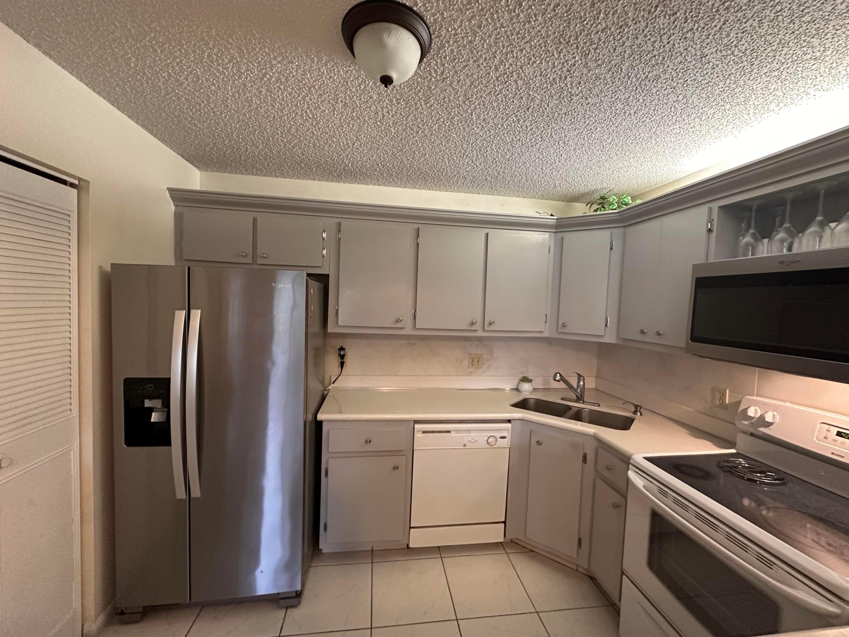 Second-floor 2-bedroom, 1.5-bath condo located in the desirable Pine Ridge IV community. Features include: open floor plan, breakfast bar, dedicated dining area, and a full-size interior washer & dryer. Both bedrooms are generously sized and offer walk-in closets. The full bathroom includes a tub with an updated tile shower surround. TILE flooring throughout. Enjoy the large enclosed patio with accordion shutters, overlooking lush garden views—an ideal space for morning coffee or relaxing evenings. Community offers a tranquil lifestyle with lake and fountain views, walking paths, grilling stations, bocce ball, shuffleboard, and a community pool. Conveniently located near the airport, shopping, restaurants, beaches, and major highways. A/C (2019) Roof (2020)