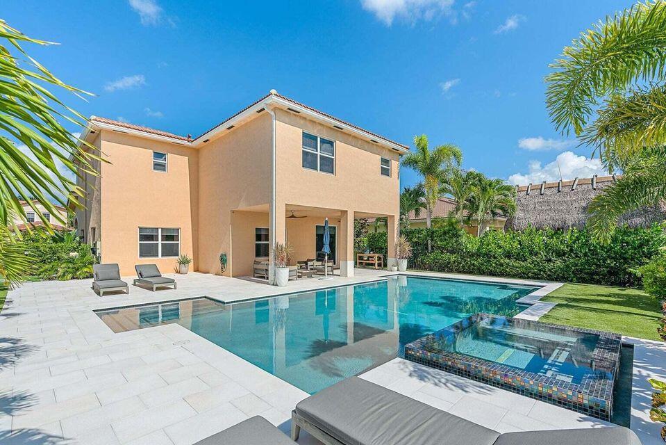 Quietly tucked away from the highway on a premium lakefront lot, this stunning CBS two-story pool home offers the perfect blend of luxury, privacy, and functionality. Featuring 5 bedrooms, 3 full bathrooms, and a 2-car garage, this beautifully maintained residence welcomes you with soaring volume ceilings, abundant natural light, and an extended paver driveway that creates exceptional curb appeal.  Inside, you'll find a NEWER 2024 A/C unit, 17" x 17" diagonal neutral ceramic tile throughout the main living areas and eco-friendly waterproof luxury vinyl plank flooring upstairs in the hallway and all bedrooms, seamlessly installed with no transition strips. The versatile floor plan includes a first-floor bedroom and full bathroom, ideal for guests or multigenerational living. Designer touches abound, including custom solar shades in the main living areas, privacy blinds in every bedroom, recessed lighting, a wood and wrought-iron staircase, remote-controlled ceiling fans, fresh interior paint, and a stunning Restoration Hardware crystal chandelier that anchors the dining space. The gourmet kitchen is designed for both everyday living and entertaining, featuring 42-inch raised cherry wood cabinetry with crown molding, granite countertops, stainless steel appliances, a large pantry, and ample storage. The spacious primary suite offers dual closets, including a generous walk-in closet, while the luxurious primary bath features dual vanities, a soaking tub, and a separate walk-in shower. A second upstairs bathroom includes dual sinks and a tub/shower combination. Built for peace of mind, the home is equipped with all impact windows and doors, gutters, and an electric vehicle charging outlet in the garage. Step outside to your private tropical retreat. The spectacular 2020 custom heated saltwater pool serves as the centerpiece of the backyard and features dual fountains, custom lighting, a spacious spa, and Pentair smart controls accessible from your phone. The pool is surrounded by an expansive marble deck with 16" x 24" pavers, a custom side-entry walkway, and synthetic turf throughout the backyard for low-maintenance enjoyment. A large, covered lanai provides the perfect setting for entertaining family and friends, while lush landscaping, solar accent lighting, and a fully fenced yard create an exceptional sense of privacy. Enjoy your own backyard orchard with mature lime, lemon, starfruit, and mango trees. Located within the highly desirable gated community of Rialto and zoned for A-rated schools, residents enjoy resort-style amenities including a community pool, splash park, basketball courts, tennis courts, walking trails, playgrounds, tot lot, and more. This exceptional lakefront home offers the complete South Florida lifestyle—luxury, privacy, recreation, and convenience—all in one remarkable property.