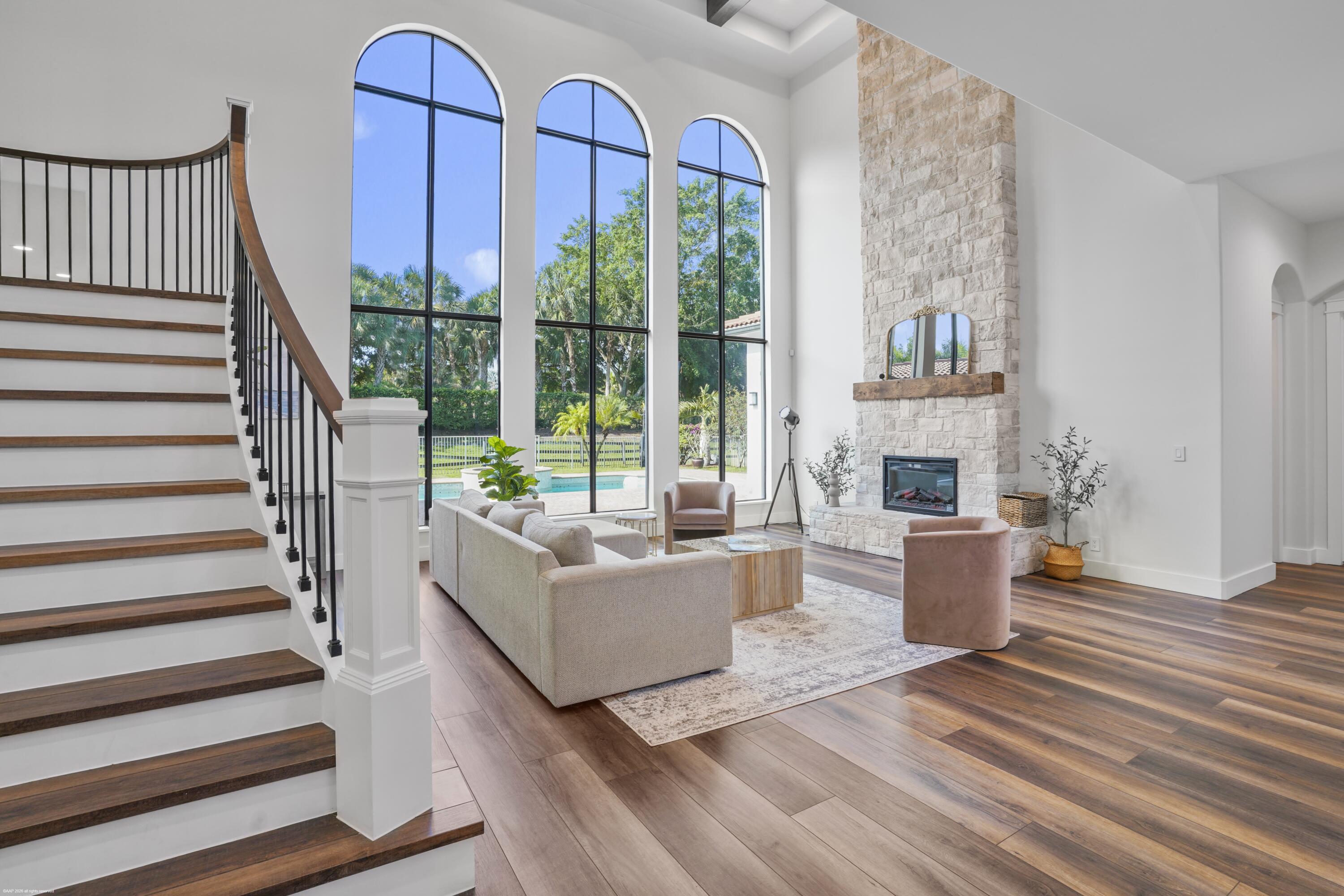 Stunningly renovated 5-bedroom residence located within Wellington's prestigious gated Equestrian Club, showcasing an impressive array of modern upgrades and thoughtful design throughout. The new center-island kitchen features elegant quartz countertops, gas cooking, new appliances, a farmhouse sink, and walk-in pantry - perfect for both everyday living and entertaining. The home boasts  upgraded luxury vinyl plank flooring throughout, complemented by resurfaced walls, new baseboards, and beautifully cased windows. A new gas water heater adds efficiency, while automatic roll-down shutters provide added security and peace of mind. The formal living room is anchored by a striking Tennessee stone fireplace with neutral tones, creating a warm and inviting atmosphere.  The primary suite offers custom-built closet, along with a luxurious in-suite bath complete with a soaking tub, new vanities, and a walk-in shower. Additional features include an office on on the ground floor and a versatile loft space upstairs and an expansive patio equipped with a summer kitchen with Webber BBQ and soapstone counters and roll-down screens—ideal for year-round outdoor enjoyment. The home has 3 AC zones - replaced in 2018, 2021 and 2023. The home includes garage space for 4 cars.  All window have recessed accordion shutters for hurricane protection. New gas hot water heater, epoxy garage floors.