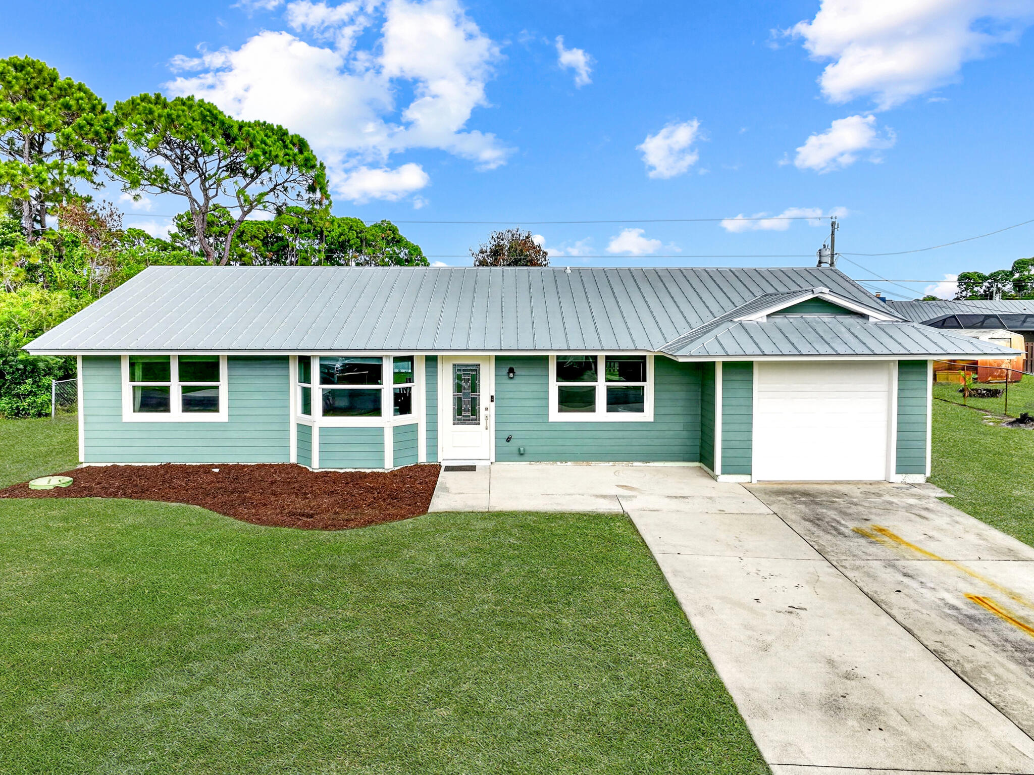 Exceptional value and move-in ready! This charming 2-bedroom, 2-bath home with a 1-car garage is situated on an oversized 0.25-acre fenced lot, offering plenty of outdoor space for pets, gardening, or future enhancements. Recent upgrades include a durable metal roof, impact windows, Hardie Plank siding, and fresh interior and exterior paint for added peace of mind and curb appeal. Inside, you'll find updated cabinetry, renovated bathrooms, and ceramic tile flooring throughout, creating a clean and low-maintenance living environment. Relax and enjoy Florida living from the dining room and kitchen coverlooking the spacious backyard. Conveniently located just minutes from Tradition and St. Lucie West, with easy access to shopping, dining, entertainment, I-95, and the Florida Turnpike.