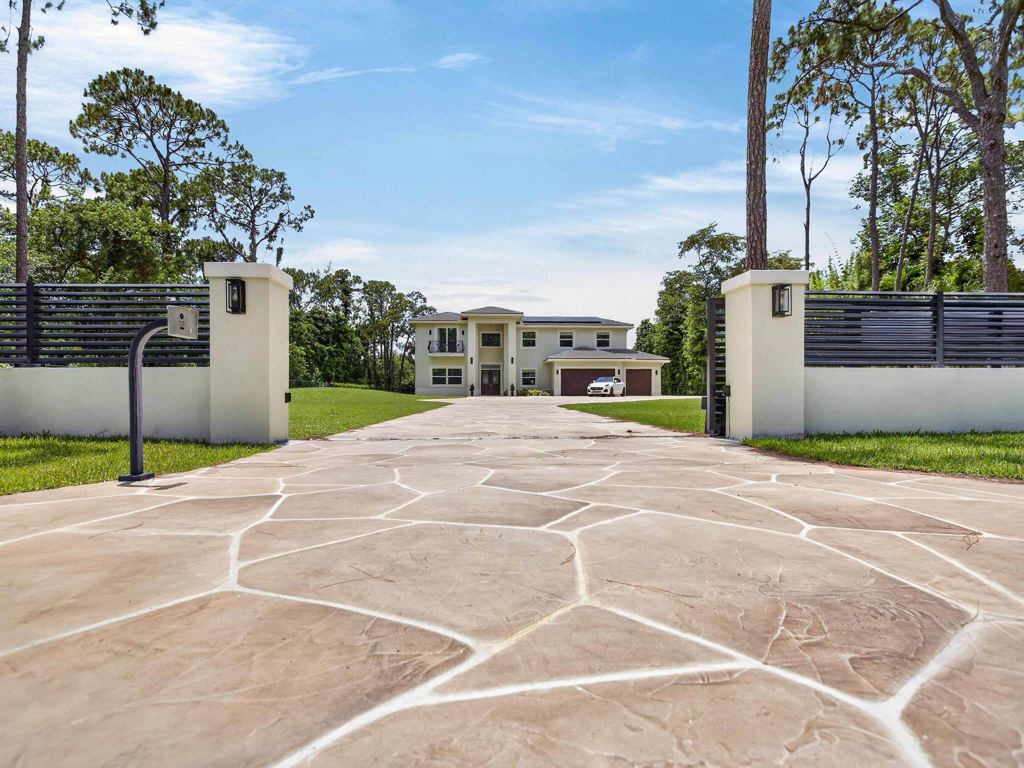 Welcome to a rare opportunity to experience luxury without limits, extraordinary privacy, and the freedom to live life on your own terms. Nestled within the prestigious Pine Tree Estates community, this exceptional property embodies the charm of Old Florida, where winding roads are shaded by majestic tree canopies and a relaxed small-town atmosphere prevails. Yet despite its peaceful setting, you're just minutes from downtown Boca Raton, Fort Lauderdale, pristine South Florida beaches, three major airports, and the vibrant metropolitan areas of Miami and Palm Beach. Parkland remains one of South Florida's best-kept secrets.    Built in 2024, this custom estate was thoughtfully designed by an owner-builder who spent decades constructing  homes for others before creating the ultimate residence for his own family. Set behind an elegant, gated entrance on more than an acre of fully fenced grounds, the property offers something increasingly rare in South Florida: luxury living without association restrictions. A striking custom Euro-tile driveway creates an unforgettable arrival experience, leading to the residence, oversized three-car garage, and expansive outdoor living areas. Inside, nearly 5,000 square feet of thoughtfully designed living space seamlessly blends sophistication and comfort. Soaring ceilings, a dramatic custom staircase, abundant natural light, and designer finishes create an atmosphere that is both grand and inviting. The versatile floor plan features five bedrooms and four-and-a-half baths, including three private suites that provide exceptional flexibility for multigenerational living, extended family, or long-term guests. At the heart of the home, the chef's kitchen showcases premium stainless-steel appliances, gas cooking, custom cabinetry, and generous gathering spaces designed for everyday living and effortless entertaining. Constructed to the highest standards, the home incorporates solid concrete block construction, poured concrete, steel beam reinforcement, impact windows and doors, and a fully insulated stand-up attic with Icynene foam insulation for superior energy efficiency, durability, and storm protection. A state-of-the-art solar energy system paired with dual Tesla Powerwall battery backups powers the home with remarkable efficiency, eliminating monthly electric bills while providing the capability to operate independently during extended power outages. Step outside and discover what may become your favorite room of the house. The resort-style outdoor living area features a stunning 35-foot heated pool and spa, expansive entertaining spaces, and a massive, screened enclosure that allows for year-round enjoyment. A separate poolside cabana with a full bath and additional storage elevates the outdoor living experience offering seamless convenience for poolside entertaining.   Beyond the pool, vast open green spaces and mature landscaping create the feel of a private country estate. Producing trees include coconut, mango, and passionfruit.  Whether your vision includes recreational vehicles, boats, hobby farming, animals, gardening, outdoor recreation, or simply enjoying the peace and privacy of your own acreage, this property provides the flexibility to create a lifestyle uniquely your own. For those seeking a home that offers luxury, security, self-sufficiency, privacy, and the freedom to live without compromise, this extraordinary Parkland estate presents a truly rare opportunity.  Call today for your private tour of this special home!