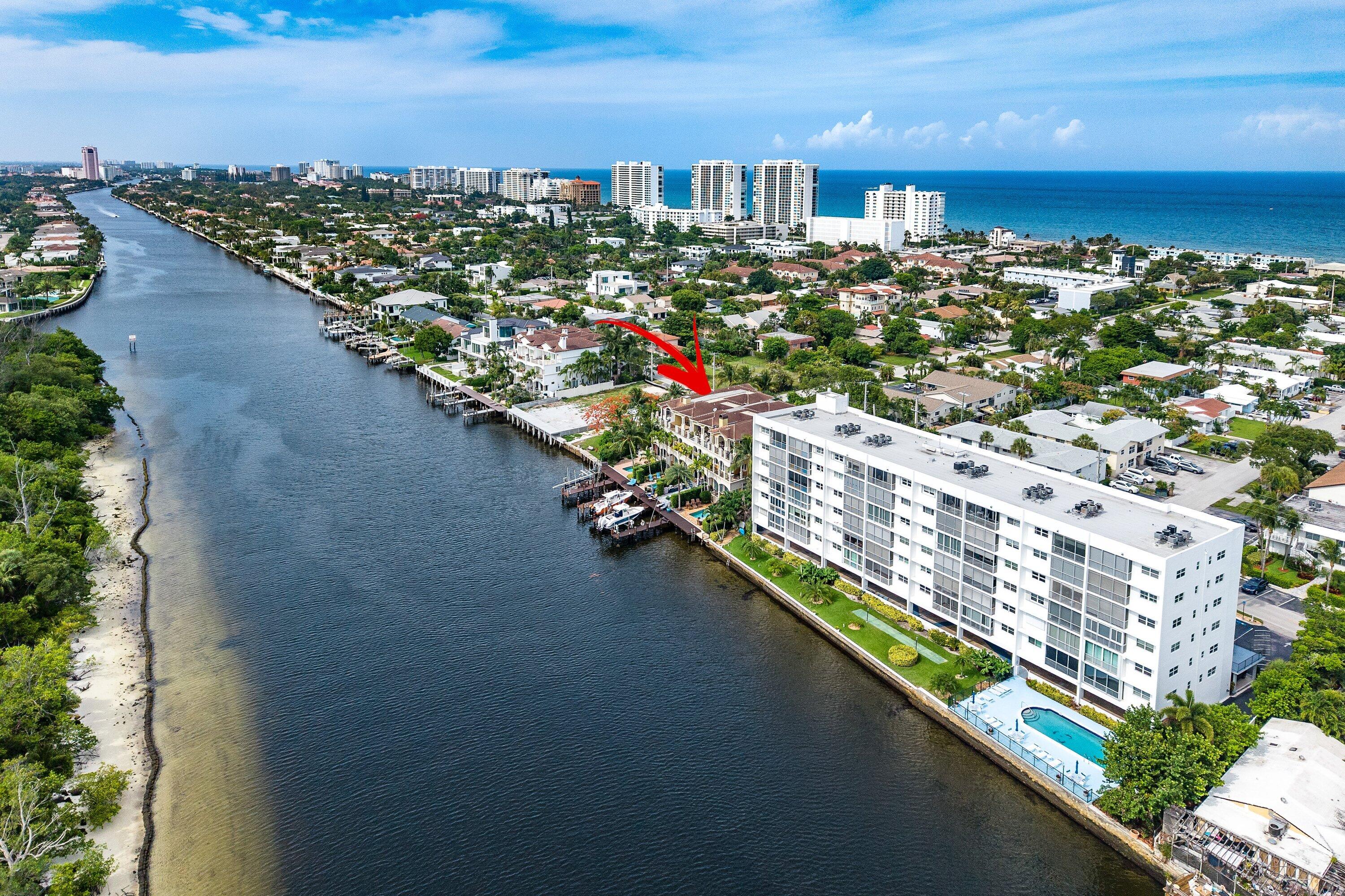 Exceptional three-story luxury waterfront townhome offering over 4,100 sq ft directly on the Intracoastal with breathtaking panoramic views, enhanced privacy, and a protected park backdrop. This rare residence combines scale, premier boating access, significant on-site parking, and added seclusion from its unique positioning adjacent to an Intracoastal park, in addition to be located directly across from Deerfield Island Nature Preserve—a highly uncommon feature in this location. Built with 12' ceilings and quality craftsmanship, the home presents a unique opportunity to update and customize to today's luxury standards while capitalizing on its irreplaceable waterfront setting and long-term value potential. Italian and Saturnia marble flooring is already in place, providing a strong  foundation for transformation.  Features include a private elevator, Hurricane impact glass, custom millwork, coffered ceilings, fireplace, Lutron lighting, and walls of glass showcasing expansive water views. The chef's kitchen is equipped with Wolf, Sub-Zero, and Miele appliances.  The residence offers four spacious en-suite bedrooms with private balconies, including a flexible third-floor club room with full bath—ideal as a guest suite, media room, or fourth bedroom. The primary suite features a private waterfront balcony, office nook, dual walk-in closets, and spa-style bath. Outdoor living is designed for entertaining, with a heated pool, summer kitchen, cabana, and expansive patio. A private dock with approximately 50 feet of waterfront and two boat lifts provides quick ocean access via Boca and Hillsboro Inlets.   A standout feature rarely found in comparable waterfront properties is the exceptional parking capacity, including a two-car garage, a full driveway accommodating up to four additional vehicles, and dedicated guest parking—ideal for entertaining and multi-vehicle households.  Combined with the property's adjacency to a quiet Intracoastal park, this creates a level of both convenience and privacy that is difficult to replicate. What further differentiates this property is its location on the famed direct Inter Coastal Waterway. There is no other address in all South Florida that is nestled right on the edge of one of the most intimate and picturesque stretches of the Waterway as this property offers a front row seat to a mesmerizing nautical parade with an endless passing of luxury yachts and unforgettable evening sunsets.   Located just two blocks from Deerfield Beach and minutes to downtown Boca Raton, this property represents a rare opportunity to create a customized luxury waterfront showpiece with unmatched boating access, privacy, and parking flexibility.