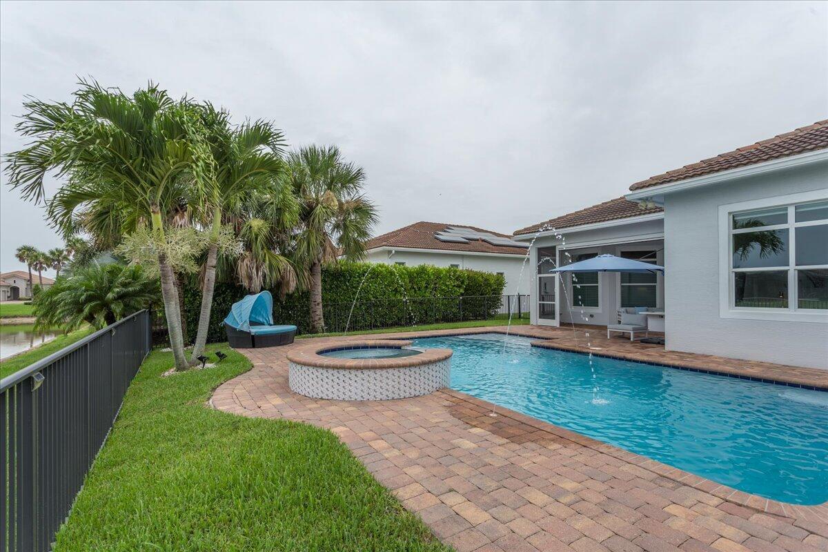 Move-in ready 4-bedroom, 2.5-bath home in PGA, offering an exceptional resort-style lifestyle. Relax and unwind by your private heated pool and spa, perfectly positioned with serene lake views—ideal for enjoying Florida evenings. The open-concept layout seamlessly connects the living, kitchen, and dining areas, creating an inviting space for both entertaining and everyday living. This designer home showcases high-end finishes throughout, including impact windows, an upgraded A/C system, elegant countertops, and thoughtfully curated details. Golf membership is available. HOA includes internet, cable, and lawn care, with access to all of PGA's outstanding amenities. Furnished purchase options are also available—ask for details