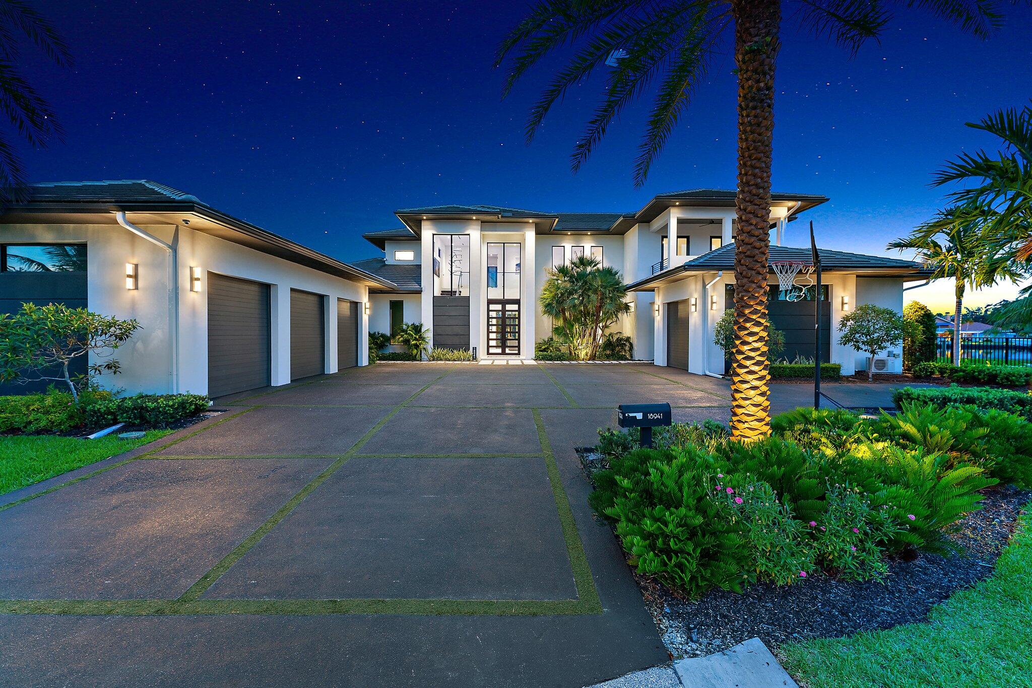 Discover unparalleled luxury in this one of a kind waterfront estate, ideally situated on a rare point lot in the exclusive, gated community of the Islands of Jupiter. This opulent residence boasts 5 spacious bedrooms and 6.5 elegantly appointed bathrooms, including a separate guest quarter. The architectural contemporary design features floating interior walls and flush wall doors, creating a sleek and modern aesthetic. The expansive living space is perfect for both grand entertaining and intimate family living. Each generously sized bedroom offers a private retreat with elegant finishes, while the spa-like bathrooms include a lavish ground floor  master suite with a steam room for ultimate relaxation. The second floor includes three bedroom additional laundry, and an expansive loft. The gourmet kitchen is a chef's dream, equipped with top-of-the-line appliances, custom cabinetry, and stunning countertops. The club room features a wet bar and two temperature controlled wine cellars for up to 300 bottles, a sommelier's delight. 
For car enthusiasts, the property includes a 4-car garage, ensuring vehicles are maintained in pristine condition, including one air conditioned space. Boating enthusiasts will appreciate the direct water access with no fixed bridges and two boat lifts as well as a separate tackle room. The beautifully landscaped grounds feature a summer kitchen and sparkling salt water pool and spa, creating a private resort-like atmosphere.
This prime location in the prestigious Islands of Jupiter offers serene waterfront views and easy access to local amenities. This exquisite property represents the pinnacle of craftsmanship and luxury living in South Florida.