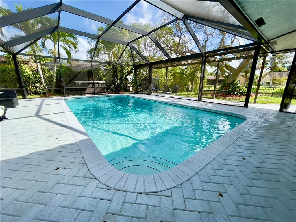 Updated 4/2.5 with split floor plan. Spacious backyard setup for entertaining. Don't miss out! 2018 NEW ROOF, 2019 NEW IMPACT GLASS WINDOWS AND SLIDING DOOR, 2022 NEW A/C 5 TON, 2022 Sprinkler Pump. UPDATED kitchen, bathrooms, as well as 2017 tile and laminate floors installed!Screened in salt pool, hot tub, outdoor kitchen. Fenced in backyard with wide canal views (great for fishing).Located within 5 minutes of Publix, dining and more. Family friendly neighborhood with multiple parks to walk to. NO HOA.