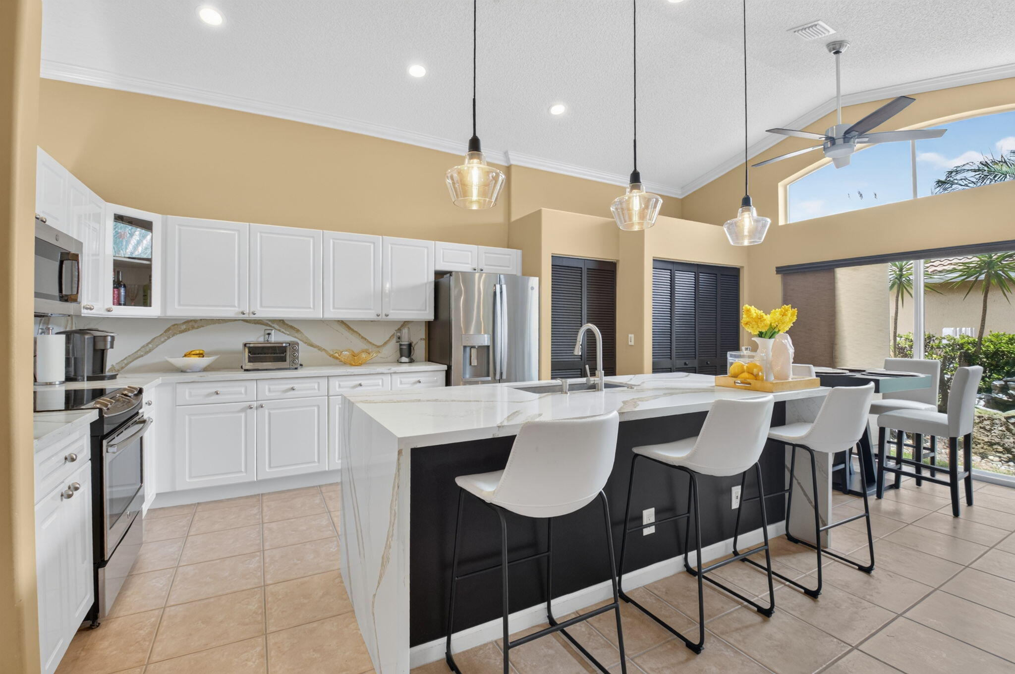 Exceptional opportunity to own this 3-bedroom, 2-bath residence situated on a desirable corner lot in the highly sought-after Winston Trails Golf Community, featuring top-rated "A" schools and no mandatory golf membership.  From the moment you enter, you'll appreciate the soaring ceilings, abundant natural light, and thoughtfully designed split floor plan. Two spacious guest bedrooms and a full bath are privately located at the front of the home, while the primary suite is tucked away in the rear, offering a large walk-in closet, dual vanities, soaking tub, separate shower, and a peaceful retreat.  The heart of the home is the beautifully updated kitchen, complete with an expansive quartz island, stainless steel appliances, oversized farmhouse sink, ample cabinetry, and open sightlines to  both the living areas and backyard—perfect for everyday living and entertaining.  Step outside to your own private oasis featuring a large covered patio, outdoor kitchen, TV area, screened lanai, fully fenced yard, and an expansive grassy area with plenty of room to add a pool. Whether you're hosting family and friends or simply enjoying South Florida's year-round outdoor lifestyle, this backyard offers endless possibilities.  Winston Trails provides an outstanding lifestyle with a championship golf course, clubhouse, fitness center, tennis, pickleball, community pool, park, pro shop, and 24-hour gated security.  Schedule your private showing today and discover everything this exceptional home and community have to offer.