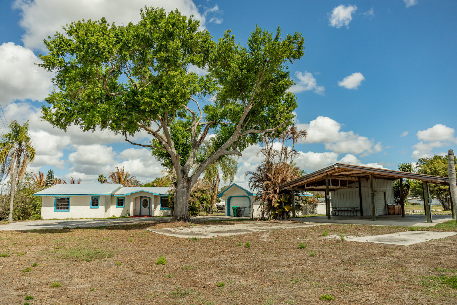 WATERFRONT LIVING WITH DIRECT LAKE OKEECHOBEE ACCESS. This home provides the ultimate Florida lifestyle in Okeechobee, Florida. Two bedrooms, two bathrooms with a large living room which centers around a fireplace, kitchen with dining. This home is perfectly positioned on a desirable corner canal lot, offering water frontage on two sides. This home is a dream for boating and fishing enthusiasts. This home is for those who love the outdoors. There is a 34 ft. by 40 ft. pole barn with a work shop. Plenty of room for your RV parking or boat. The garage is 15 ft. by 30 ft. One enclosed boat garage/slip with stairs leading to the concrete roof deck. There is an additional covered boat slip, giving you two boat slips.
