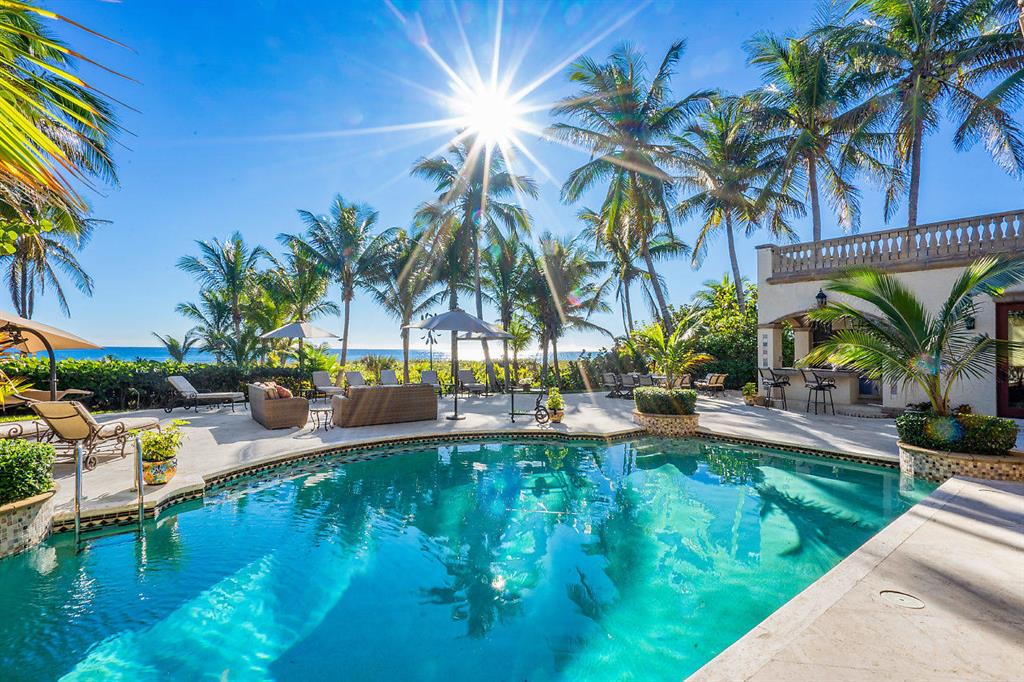719 North Ocean Blvd, Delray Beach – A prestigious example of sumptuous architecture perched high among the South Florida dunes of the Atlantic Ocean in Delray Beach. Take immediate occupancy in this substantially furnished estate. A true trophy property, this oceanfront estate stretches across 101' of direct beach frontage creating a tropical paradise worth reveling in. It is an extreme rarity that you will find an opportunity such as this – offering nearly a half-acre of oceanfront living sited .8 miles to famed Atlantic Avenue. The ideal combination of location, convenience and luxury awaits you.. An entertainer's dream, this exceptional property evokes the indoor/outdoor living highly sought after by South Florida residents. Interior highlights of this 1998 estate include 5-bedroom... suites, an office with airy ocean views, spacious chef's
kitchen with natural gas, convenient home gym, Carrera marble floors and endless views of the cool blue ocean waters.
Extending throughout a total of 8,585 square feet, this truly private & gated tropical resort setting emphasizes elite amenities such as a guest house, a full outdoor kitchen, an oversized pool/spa, and a lushly landscaped, playfully winding path to your own beach access.
Towering up above the ocean, this property is delightfully framed on both sides by mature Royal Palm trees and other native tropical foliage masterfully crafting the picturesque culmination of intimate, serene living with the best ocean views imaginable. For a 3D Tour, https://my.matterport.com/show/?m=eWzfz1kNGda