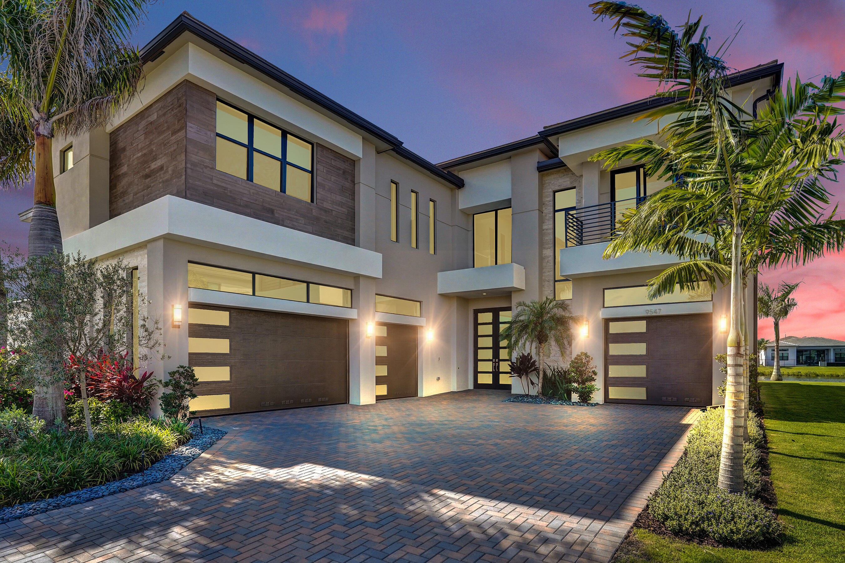 Welcome to this exceptional waterfront residence in Lotus Edge, Boca Raton. The only brand-new, move-in-ready Santorini model currently available on the market, this highly sought-after floor plan offers the perfect blend of luxury, comfort, and sophisticated design.  This stunning two-story home features 5 bedrooms, 7 bathrooms, and 5,453 square feet of beautifully finished living space. Designed for both everyday living and grand entertaining, the home showcases exquisite finishes throughout, expansive living areas, and multiple indoor and outdoor spaces ideal for hosting family and friends.  The gourmet kitchen, elegant gathering spaces, and seamless indoor-outdoor flow create an exceptional lifestyle experience. A spacious four-car garage provides ample parking and storage. Situated on a premium waterfront lot, the property offers tranquil water views and the distinctive appeal of waterfront living within one of South Florida's most desirable new luxury communities. Residents enjoy access to Lotus Edge's world-class amenities, resort-style clubhouse, fitness center, pools, sports courts, and more.  A rare opportunity to own one of the community's most desirable models without the wait of new construction.  Some photos have been virtually staged.