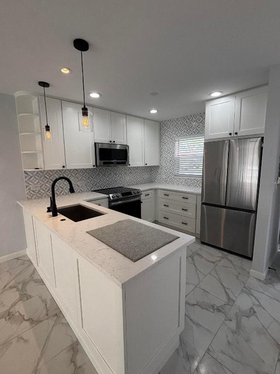 MOTIVATED SELLER! dont miss this opportunity for a turn key home LOW HOA! This unit is absolutely stunning. This single story beautifully renovated 1-bedroom, 1.5-bath villa has been thoughtfully updated from floor to ceiling. Enjoy porcelain flooring throughout and an open-concept kitchen enrobed in quartz countertops, white shaker cabinetry, and stainless steel appliances. Both bathrooms have been tastefully remodeled  Principal room has a large walk in closet with ample space for all of your belongings. Relax in the serene Florida room, now fully enclosed with brand-new windows--an upgrade from the traditional screened enclosure--complete with a ceiling fan and A/C vent for year-round comfort.  Enjoy the comforts of parking right in front of your unit, washers & dryers in the Community NO FHA OR VA