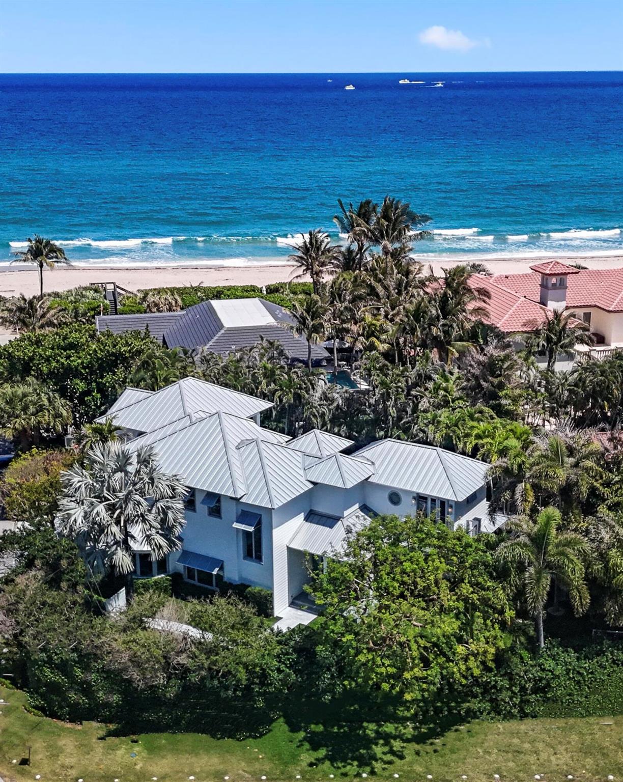A rare oceanfront opportunity awaits!  Nestled on nearly 1/2 an acre in the highly desirable and quaint seaside town of Ocean Ridge, and located just minutes from Palm Beach and Downtown Delray, this truly turnkey transitional coastal modern home boasts ocean views and over 50ft of private beach space including your own large dune deck.  No expense was spared in the full gut renovation of this stunning home. As you enter the gated property and walk along the winding pathway, you can hear the sounds of the ocean, smell the saltwater in the air, and feel the sense of tranquility that comes from the private, spacious, tropical yard.  As you enter the home, you are immediately struck by the soaring vaulted ceilings and walls of glass creating a bright and airy sanctuary. The new white oak floors that run throughout as well as the fresh white paint and designer fixtures underscore the luxury beachside feel of the home. The open living and formal dining room lead into a completely remodeled eat-in chef's kitchen boasting solid wood custom cabinetry, quartz countertops, a 6 burner gas cooktop, new Miele dishwasher and coffee machine, a new high-speed Miele oven, and a newly built out walk in pantry with two Sub Zero wine refrigerators and freezer.  The kitchen and living room open onto the fully fenced in tropical backyard oasis which includes a large covered patio, brand new heated saltwater pool and spa, summer kitchen, outdoor shower, and grass turf. Both of the oversized main-floor bedrooms enjoy spacious built-out closets and generous natural light, with one of the bedrooms boasting a completely renovated ensuite bathroom with quartz countertops and designer tile. The striking stairway leads to the sunny second floor where you will find the primary suite and an additional bedroom with ensuite bath, ocean views, and a private balcony.  The master suite is a truly elevated and luxurious retreat with its own wraparound veranda, separate sitting area, an expansive built-out walk-in closet, and a designer bathroom to rival even the highest end hotel spas complete with steam shower and heated toilet seat.  The spacious 3-car garage offers ample storage, has been newly epoxied and includes a newly installed lift for automobile collectors as well as an electric car charger. Enjoy the very best of oceanfront living whether it's from your gorgeous new home, the tropical oasis grounds, or the private beach just steps from your front door!