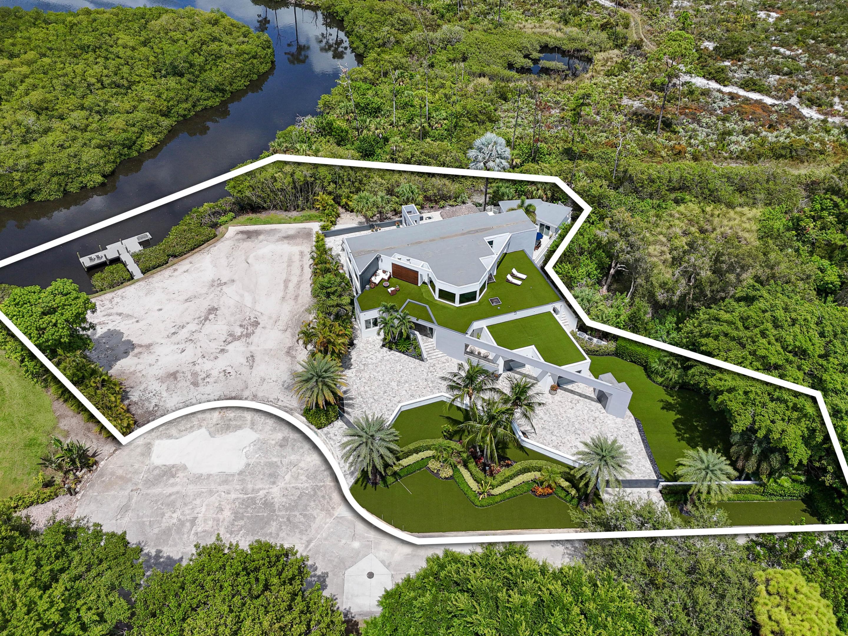 Two Lots being sold together .76 acres combined on the River with 140 ft of water frontage and ocean access. Lot 8 is fully developed with a Stunning Newly Renovated House, Guest House, and Property. Riverfront Lot 9 has been cleared, filled, and graded, setting the stage for your future vision. Both properties sit elevated high and dry. Ready to build on, or it can be combined with the current home (Lot 8) to make one large property on the River. New Large Dock, Pilings and a New Floating Dock are already in place. All utilities are in place. A Special Property with a 'LOT' of upside potential. Situated adjacent to JD State Park and next to the Loxahatchee River, providing Extraordinary Views and Sunsets. Located just minutes to the beach & town center.  This impeccable residence offers a Large Captivating Heated Salt Water Pool with Glass Tile and a baby/kid friendly pool shelf, Built-In Cedar Sauna, Turf Rooftop Decks & Lawn, Expansive Silver Travertine Driveway and Pool Deck with Hardscaping, spacious Covered Lanai, sizable Tiki Hut, plus a Private Gated Entry. 5 Bedrooms, 5 Bathrooms of Airy Living Space with Abundant Natural Light. Awe-Inspiring Primary Bedroom Suite with an office and outside shaded deck offers breathtaking views of the River & Park. A Large Private Property with Hiking/Biking trails from your back door access. New Roof, Entrance & Exit Driveway Gates, Hardwood Floors, Tiki Hut, Extensive Landscaping, Hardscape work including Black Polished Stones surrounding the property, Gourmet kitchen, Two dramatic and elegant wood burning porcelain fireplaces, Custom Glass staircase railing, Impact  Windows and Doors, New Oversized Impact Garage Doors, Three car garage w/ finished floor, Large driveway with ample parking for cars, boats, or RV. Security cameras & Alarm system. No HOA fees and low Martin County taxes. Just minutes to shopping, fine & casual dining, entertainment, and the beach. PBI is 25 minutes away.