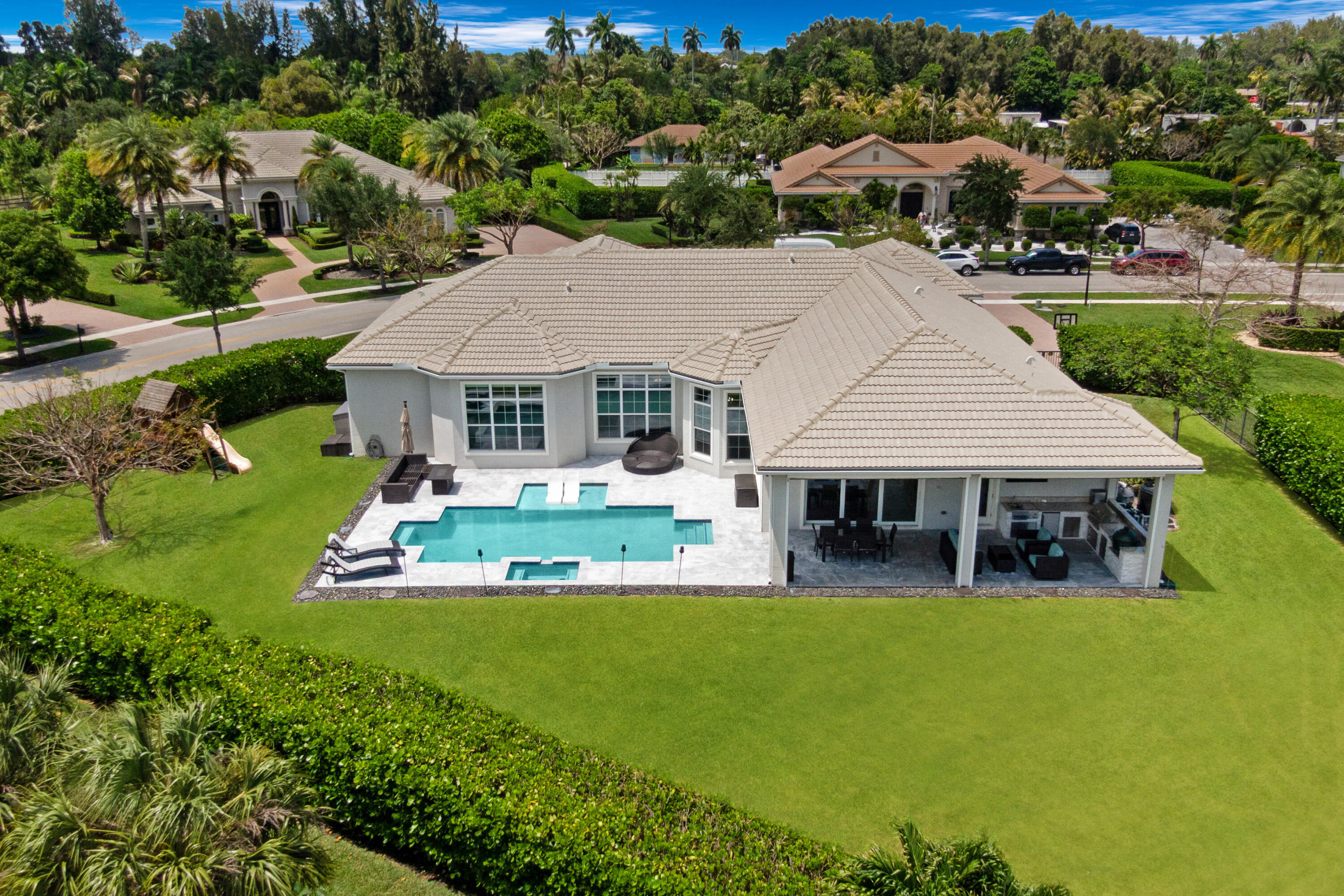 Flexible 4-bedroom home with a large guest suite/office that easily functions as a potential 5th bedroom. This luxury lakefront estate within the prestigious gated Sterling Ranch community  offers over 4,000 square feet of thoughtfully designed living space, a resort-style saltwater pool, sweeping water views, and exceptional indoor-outdoor living. The home's split floor plan creates exceptional privacy, with a dedicated primary suite and office wing separated from the guest bedrooms. Designed for both entertaining and everyday living, the expansive layout includes two spacious living areas, a formal dining room, breakfast nook, and a chef's kitchen with oversized peninsula seating for four. The kitchen features double wall ovens, designer hood, cooktop, maple cabinetry, granite countertops, built-in desk area, and a large walk-in pantry. Throughout the home, 8-foot interior doors enhance the scale and luxury feel of the space. The luxurious primary suite serves as a private retreat with automatic custom shades, oversized dual walk-in closets, and a spa-inspired bathroom. Two guest bedrooms include private ensuite bathrooms, while the fourth bedroom with adjacent full bath is ideal for guests or multigenerational living. Step outside to a resort-style waterfront backyard featuring a heated and cooled saltwater pool with spa, sun shelf, bubblers, LED lighting, built-in bench seating, and in-water loungers. The covered lanai includes a fully equipped summer kitchen with built-in grill, sink, refrigerator, and Kevlar storm-rated automatic screens, creating seamless indoor-outdoor living year-round. Additional highlights include full impact windows, doors, and garage doors, built-in family room speakers, intercom system, home automation capability, oversized laundry room with direct access to the 3-car garage, custom recessed soffit lighting, outdoor speaker system, elegant aluminum fencing, and professionally maintained landscaping included with HOA fee. Conveniently located near shopping, dining, entertainment, and major highways, this Sterling Ranch lakefront home offers a rare combination of luxury, privacy, modern functionality, and exceptional South Florida lifestyle living.