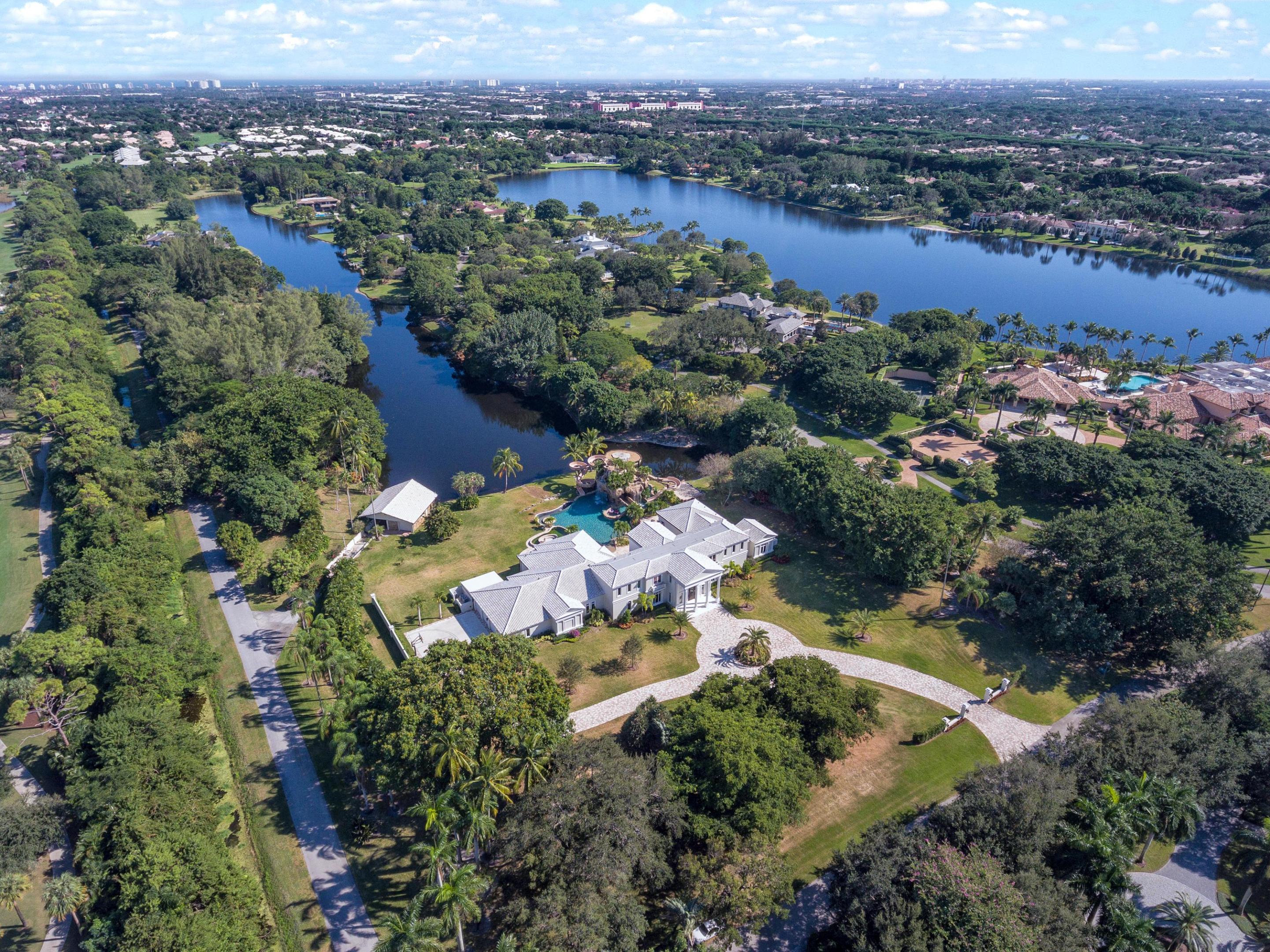 FEATURED ON CNBC. LOCATED IN THE EXCLUSIVE LE LAC ESATE, THIS FAMILY COMPOUND IS SITUATED ON 6.4 ACRES OF LAKEFRONT RESORT-STYLE LIVING. THIS 14,874 SQFT ESTATE (INCLUDING 11,281 UNDER AIR) BOASTS 8 BEDROOMS, 9 FULL BATHS AND 1 HALF BATH WITH THE MASTER SUITE LOCATED ON THE MAIN LIVING LEVEL. THIS CUSTOM ESTATE WAS DESIGNED FOR INDOOR AND OUTDOOR FAMILY ENTERTAINING AT ITS FINEST. THE RESIDENCE FEATURES A TOP OF THE LINE HOME SECURITY SYSTEM, MARBLE FLOORING, BASKETBALL COURT, 4 GARAGES, ONE OF A KIND CUSTOM ATLANTIS-STYLE POOL WITH WATERFALL, 2 SLIDES AND A LAZY RIVER. THE OUTDOOR KITCHEN AREA FEATURES GRANITE COUNTER TOPS, BUILT IN GRILL AND OVEN ALL LOCATED UNDER AN OPEN PATIO AREA THAT ALLOWS FOR GRACIOUS ENTERTAINING. THIS IS AN INCREDIBLE VALUE! A PRIVATE BOATHOUSE INCLUDING DOCK ALLOWS FOR ACCESS TO THE LAKE DIRECTLY FROM THE PROPERTY. LE LAC OFFERS THE ULTIMATE IN PRIVACY AND 24-HOUR SECURITY IN ONE OF SOUTH FLORIDA'S MOST SOUGHT AFTER COMMUNITIES. PLEASE NOTE AN ADDITIONAL 1.5% IMPACT FEE TO PURCHASE PRICE IS MANDATORY PER HOA AND DUE AT CLOSING.