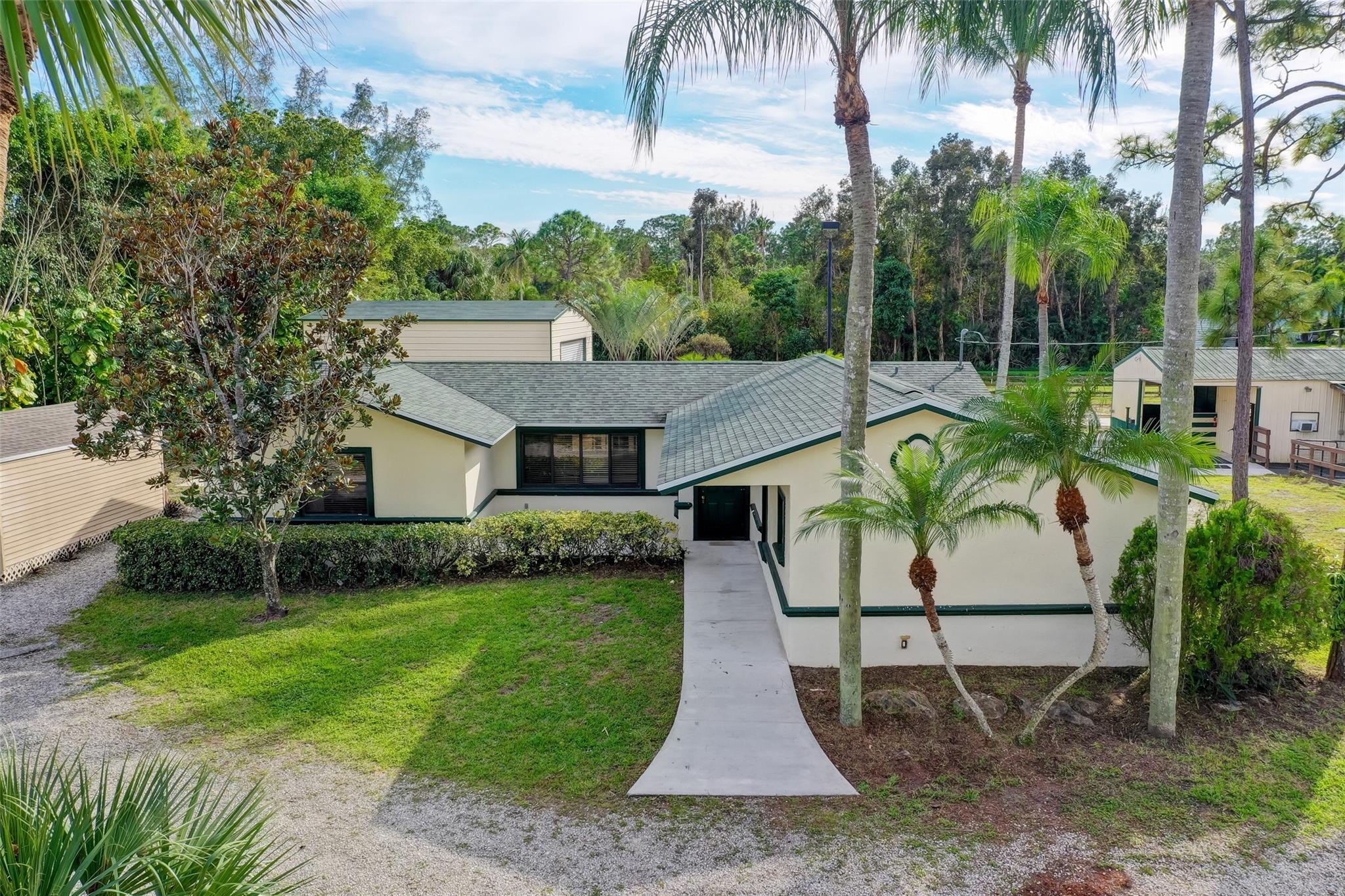In the heart of West Palm Beach with no HOA or restrictions this 1.25 acre fully fenced property offers unmatched value and versatility. As you approach, a charming 3-bedroom, 2.5 bath home with a screen patio and a Florida sunroom and inviting porch welcomes you. A standout feature is the expansive workshop with 16' roll up door, high ceilings and concrete floors perfect for a boat, a workshop or car storage. Equestrian enthusiasts will appreciate the 5 stall rubber matted barn with turnout and exercise ring. Palm and pine trees adorn the landscape with lots of lush vegetation and privacy. Adjacent to the home there is an added shed, with and wall AC unit. This property is tailor-made for anyone's aspirations, perfect for small Business owners, Equestrians, Families or Investors. Gate for the property Is open just Push Gate Manually, Lock box on the Front Door.