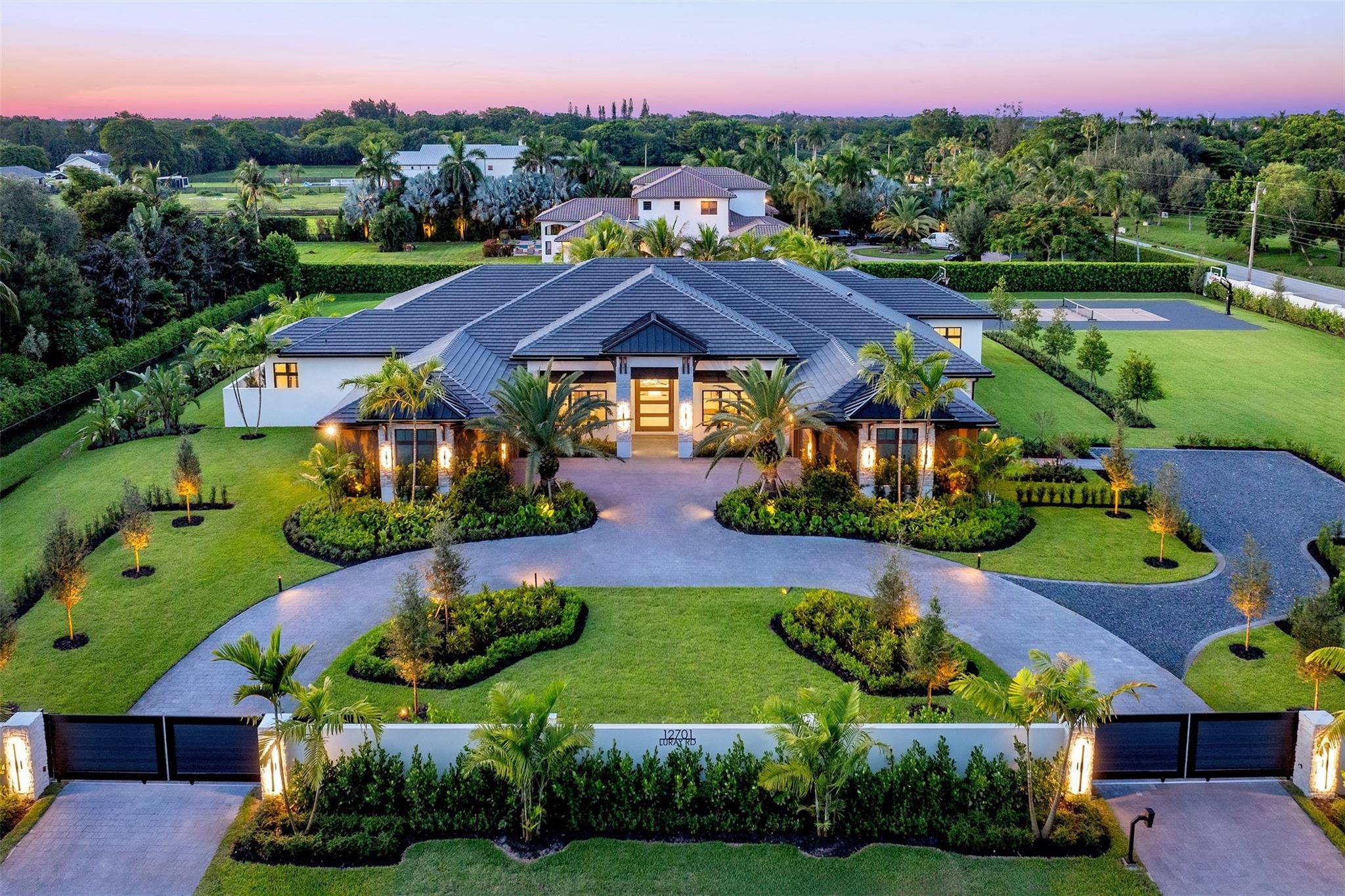 Luxury meets lifestyle in Southwest Ranches this design-inspired estate offers +-10,000 SF of Indoor/Outdoor living space & sits on more than 2 acres. A true compound featuring concrete privacy wall, automated gated entrances and a 4 car garage. Interior features 5 spacious bedrooms plus a dedicated library/office, gym, club room, & 6.5 baths. Open-concept layout anchored by an iconic stone fireplace. The chef’s kitchen is a showstopper with Wolf appliances, 60” gas range, Cristallo countertops, & dedicated prep and storage area. Cool off in your resort-style heated pool, raised spa, swim-up bar, & a fully equipped outdoor kitchen and enjoy a newly built full court basketball and pickleball court surrounded by lush landscaping. Southwest Ranches is the crown jewel of Broward County. No HOA
