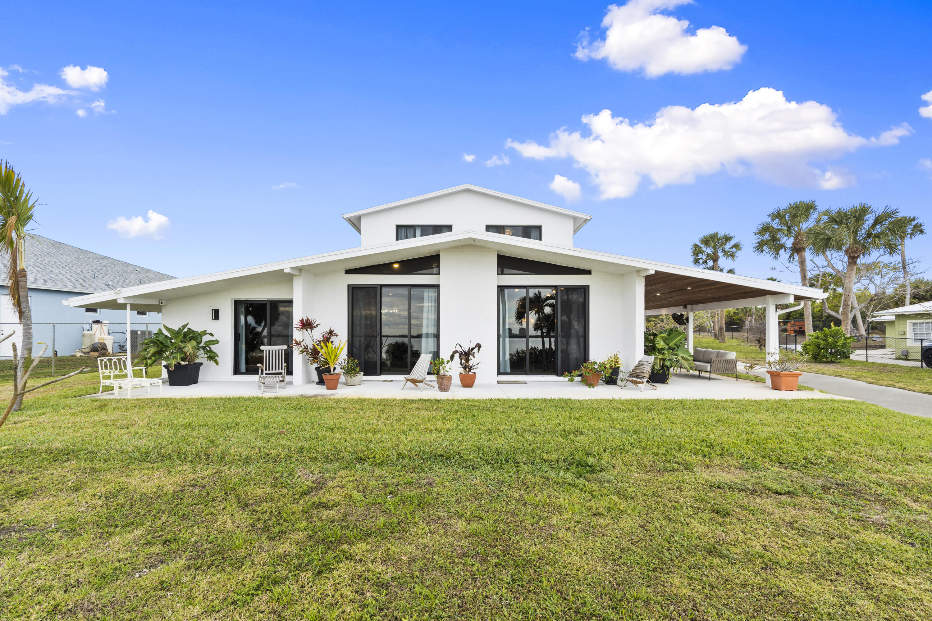 This is what Indian River Drive living is supposed to feel like. Set on 1.15 acres with 95 feet of direct river frontage, this reimagined contemporary estate delivers along one of Florida's most iconic scenic routes. Every inch of this two-story residence blends timeless character with modern luxury across 5 bedrooms, 3 bathrooms, and over 2,700 square feet of living space. Inside, volume and texture take center stage. Soaring cypress plank ceilings and original terrazzo floors ground the home in authenticity. The kitchen is anchored by quartz countertops, an antique island, gas range, stainless steel appliances, open shelving, and a designer tile backsplash. Impact windows throughout capture breathtaking river views from nearly every room. Recent upgrades include a 2024 metal roof, 2025 water heater, 2018 A/C, and a 125-gallon whole-house diesel generator for year-round peace of mind. Upstairs, a fully equipped private apartment offers exceptional versatility with a private entrance, two bedrooms, a full bath, spacious living area, kitchenette, in-unit washer and dryer, and its own porch overlooking the water. Outdoors, a covered patio with a summer kitchen and full outdoor bath is built for effortless entertaining, all set against a stunning riverfront backdrop. The private dock is dialed in with new water lines, 6-gauge electric, and a 20,000 lb. lift capable of accommodating up to a 40-foot vessel. A 2-car garage/workshop, attached 1-car garage, 2022 irrigation system, and a dedicated backyard septic system already in place for a future guest home or RV.