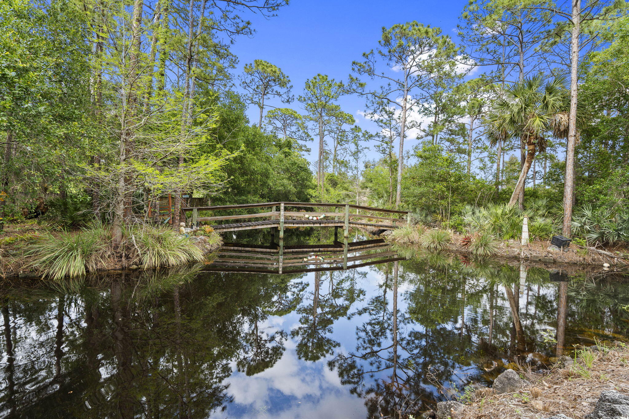 Welcome to your Private Countryside Retreat—where Space, Serenity, and Endless Possibilities come together on 2.06 beautifully expansive acres. This charming 2 Story Rustic Ranch is designed for those who crave room to roam and a lifestyle connected to nature. Whether you're raising a Family, caring for Equestrian animals, or simply enjoy wide-open spaces, this property delivers the freedom you've been looking for. Inside, you'll find warm and inviting features, including rich Oak Cabinetry, gleaming Granite Countertops, and a thoughtfully designed kitchen with a convenient Pass-through window to the oversized screened patio—perfect for effortless indoor-outdoor entertaining. The home is equipped with New Impact Windows and durable Metal roof, offering peace of mind for years to come. The Private Master Suite is tucked away on the second floor, creating a true retreat complete with its own balcony—an ideal spot to take in breathtaking Sunset Views. Start your mornings on the expansive front porch with a cup of coffee as the sun rises over your peaceful property. Step outside and experience everything this property has to offer. Spend warm days enjoying the east/west exposed pool, unwind in the hot tub after a long day, or host unforgettable gatherings under the large pavilion featuring countertop seating, water, and power—ready to be transformed into your dream outdoor kitchen. From birthday parties to weekend BBQs, this space was made for making memories. For the outdoor enthusiast, the stocked pond offers the perfect escape for fishing, while the expansive acreage provides ample room for animals, recreation, or even a home-based business. An existing 1,100 sq ft CBS structure—currently dog kennels—offers incredible flexibility and can easily be repurposed into an in-law suite, home office, stable, or garage for your toys. The rear property is fenced in paddocks for your furry friends. With a little vision and finishing touches, this One-of-a-Kind property can become your Forever Homestead—a place where your lifestyle dreams truly come to life.