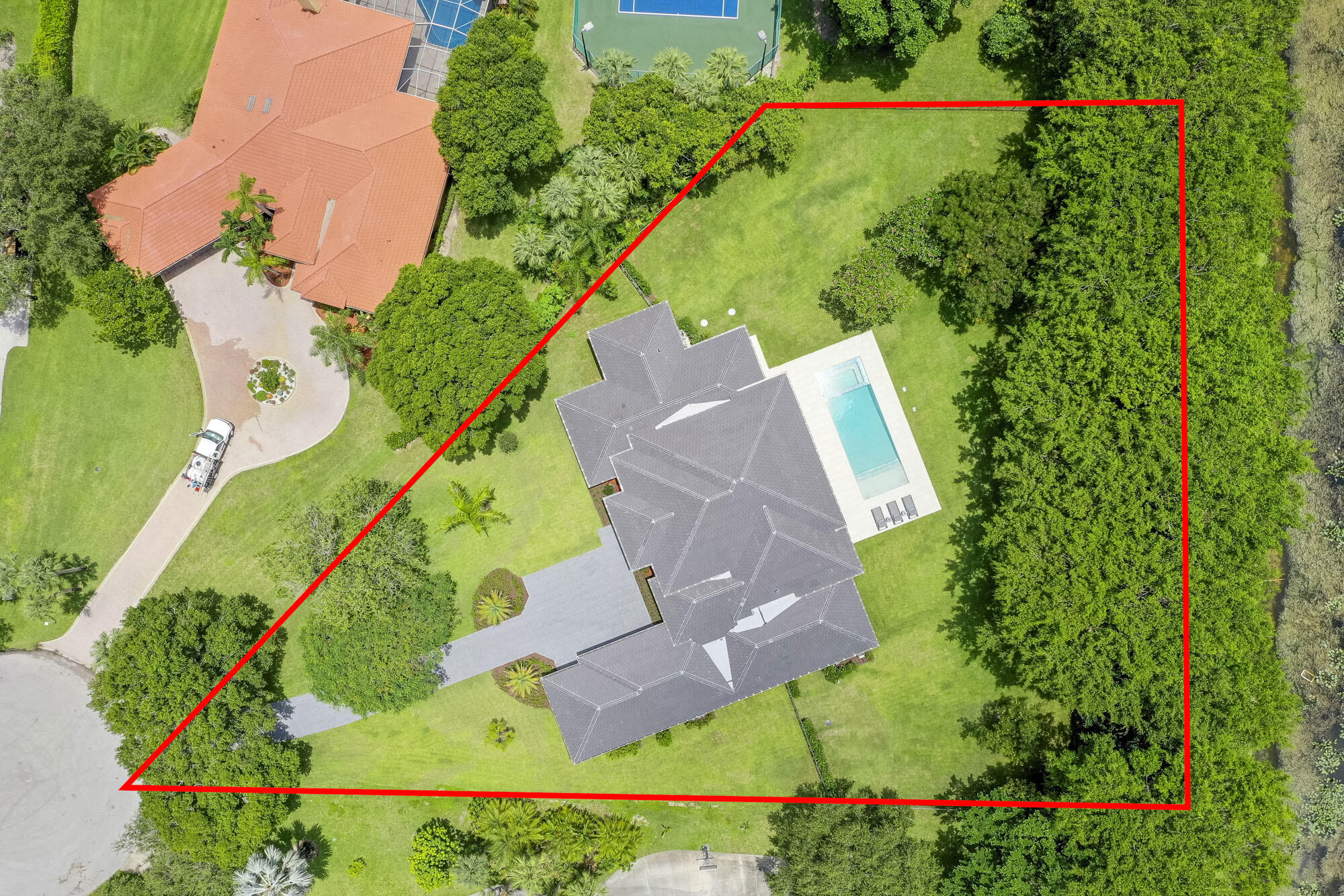 Introducing a new benchmark of luxury and refinement in the heart of Palm Beach Gardens' most sought-after neighborhood. This exceptional new construction home spans over 4,700 square feet of unrivaled grandeur, unmatched scale and unparalleled craftsmanship. From the very moment you step inside, the meticulous attention to detail, seamless flow, and expansive vistas create a truly elegant and modern living experience. As the sleek floor to ceiling sliders gracefully disappear, an awe-inspiring indoor/outdoor living experience unfolds, revealing breathtaking views of your private 1.3 acre backyard and an extravagant resort-style pool. With an air of sophistication and contemporary flair, this extraordinary estate boasts 6 bedrooms, 6 bathrooms, 3 car garage, a spacious office, and versatile flex space. Towering volume ceilings create an atmosphere of grandeur, while the state-of-the-art kitchen, outfitted with top-of-the-line Sub Zero and Wolf appliances, caters to culinary enthusiasts. Beautiful mature trees surround the property, which rests just at the end of the cul-de-sac, offering ultimate privacy.