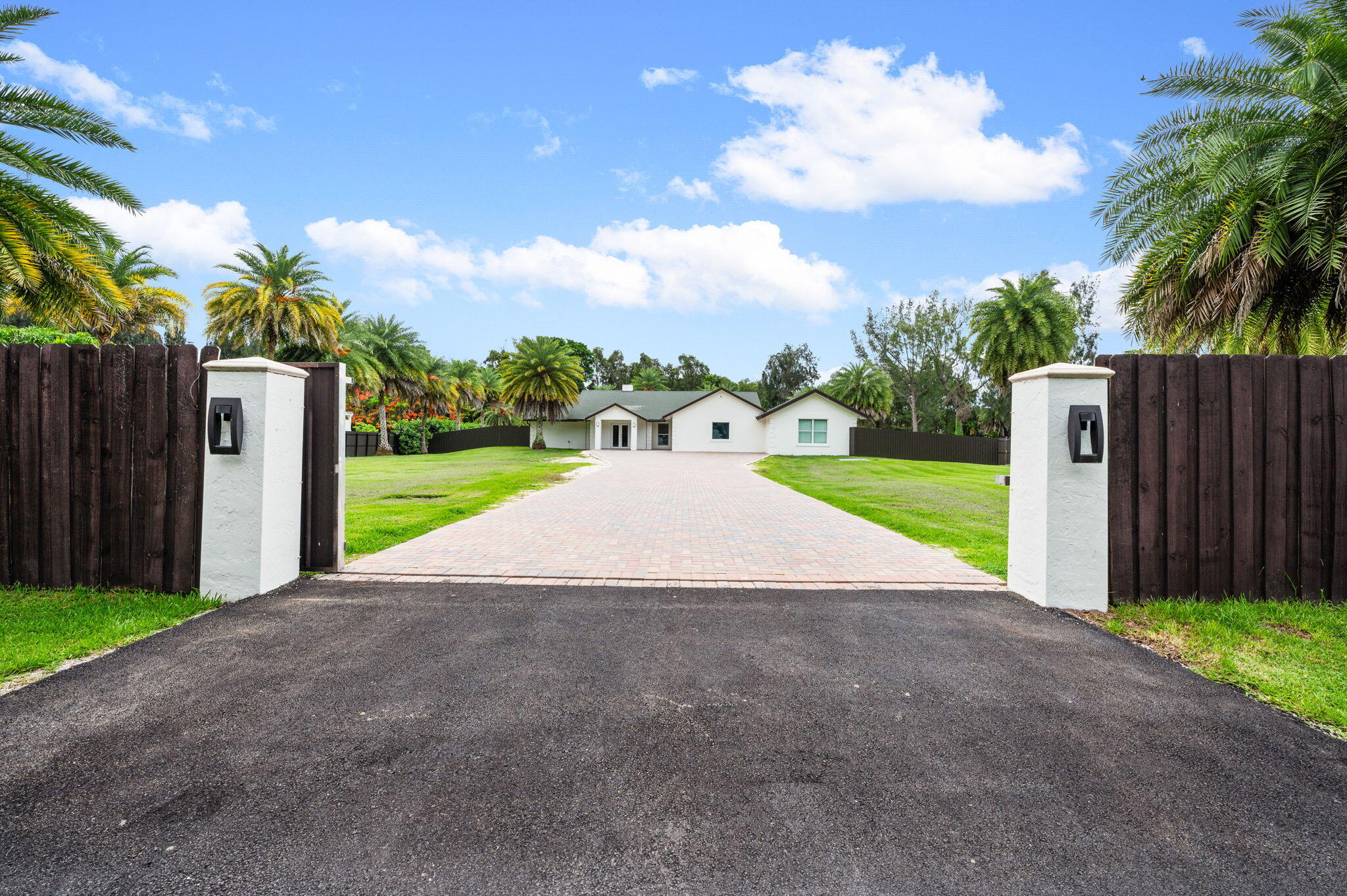 Welcome to your private retreat on a corner, fenced acre with an electric entry gate on a quiet no-through street; this estate offers privacy, flexibility, and the coveted SW Ranches lifestyle. The main residence has 3 beds, 3 baths and 2,683 sq ft. With 2 master suites, updated baths, impact windows, a chef's kitchen with premium Wolf and Thermador appliances, tropical pool and lush backyard setting. The property also has a standalone AC enclosed outdoor kitchen for grand entertaining. Additionally, it includes a guest house/in-law suite with its own bedroom, bath, kitchen, private entrance, and separate driveway—perfect for multigenerational living, a home office, or potential income-producing opportunities. More than a home—it's a compound for thriving and memories for years to come!