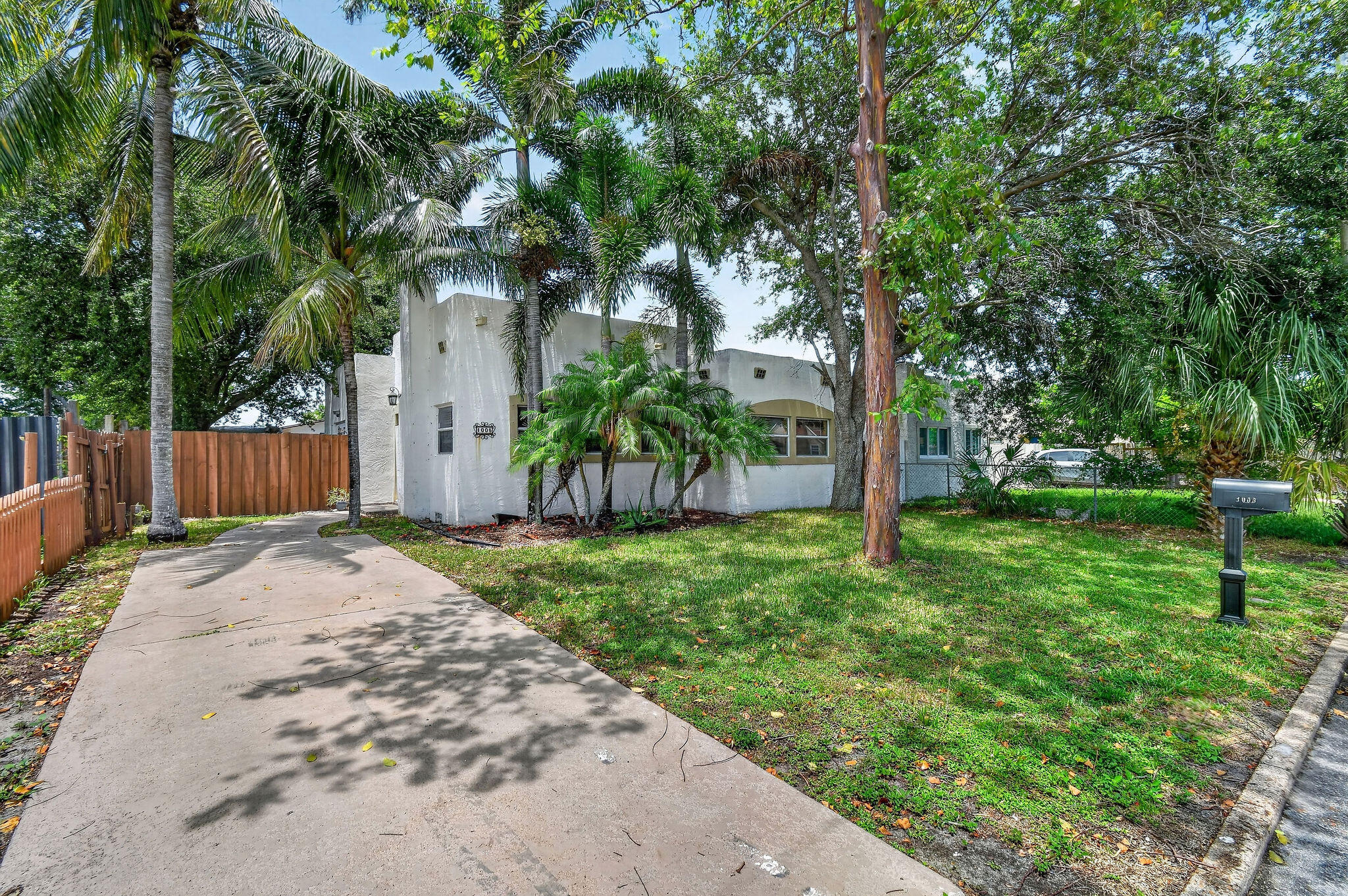Charming 3BR/1BA Spanish-style home available for annual rent on a wide, quiet street in West Palm Beach. This inviting residence features double glass entry doors and abundant natural light throughout. The kitchen offers tile countertops, a tile backsplash, and built-in display shelving. A spacious flex room off the kitchen can serve as a formal dining room, family room, or additional living area. The large utility room provides ample space for laundry and extra storage.The fenced backyard features mature shade trees, tropical palms, a paver patio, and access from both the kitchen and primary bedroom. A matching stucco garden shed provides additional storage. Conveniently located near I-95, Palm Beach International Airport, Downtown West Palm Beach, shopping, dining, & the Palm Beach Zoo.