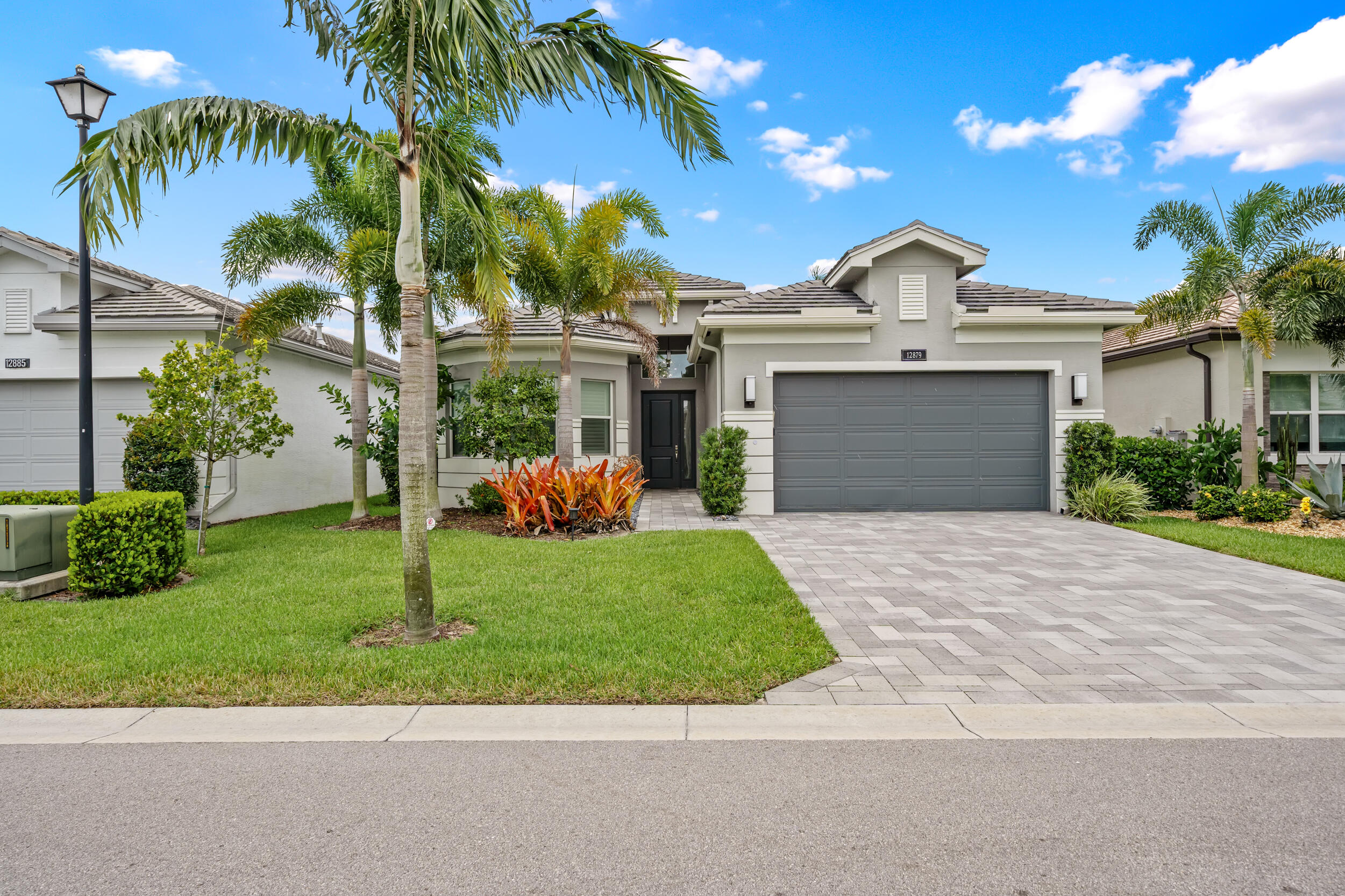 Experience elevated lakefront living in one of Boynton Beach's most sought-after 55+ luxury communities. Perfectly positioned on a premium waterfront homesite, this highly desirable Bimini model offers 3 bedrooms, a private office/den, 3 full bathrooms, and a thoughtfully designed open-concept floor plan that blends elegance, comfort, and functionality. From the moment you enter, soaring ceilings, abundant natural light, and breathtaking lake views create an immediate sense of space and sophistication. Oversized 24" x 24" rectified porcelain tile flows seamlessly throughout the main living areas, while expansive windows showcase the spectacular waterfront setting and the beautifully illuminated fountain that creates a stunning backdrop both day and night.     The gourmet kitchen is designed to impress, featuring natural gas cooking, GE Profile appliances, abundant cabinetry, premium finishes, pull-out storage, and a layout that opens beautifully to the spacious living and dining areas—perfect for entertaining or everyday living. One of the home's most remarkable features is the oversized screened lanai, offering an exceptional outdoor living space rarely found in today's market. Whether enjoying your morning coffee, hosting guests, or simply relaxing while overlooking the tranquil lake and fountain views, this outdoor retreat captures the very best of the Florida lifestyle. Additional highlights include a widened paver driveway, upgraded landscaping, solid-core interior doors, upgraded vanity cabinetry, a 75-gallon water heater, and numerous custom upgrades throughout. Unlike many homes, this residence has been gently enjoyed by seasonal owners and occupied only a fraction of the year. The result is a home that feels exceptionally maintained, remarkably fresh, and almost like new. Beyond the home itself, Valencia Sound delivers a lifestyle second to none. Residents enjoy an approximately 39,000-square-foot clubhouse featuring a full-service restaurant, sports lounge, social hall, resort-style pool, lap pool, resistance pool, spa, state-of-the-art fitness center, arts and crafts studios, card rooms, demonstration kitchen, and an endless calendar of clubs, events, and entertainment. Sports enthusiasts will appreciate the world-class racquet facilities, including 11 lighted pickleball courts, 6 lighted tennis courts, bocce courts, professional instruction, tournaments, and social leagues. This is more than a home—it is a luxury resort lifestyle where every day feels like a vacation. Rarely does a waterfront Bimini model with such exceptional views and pristine condition become available. Don't miss this extraordinary opportunity.