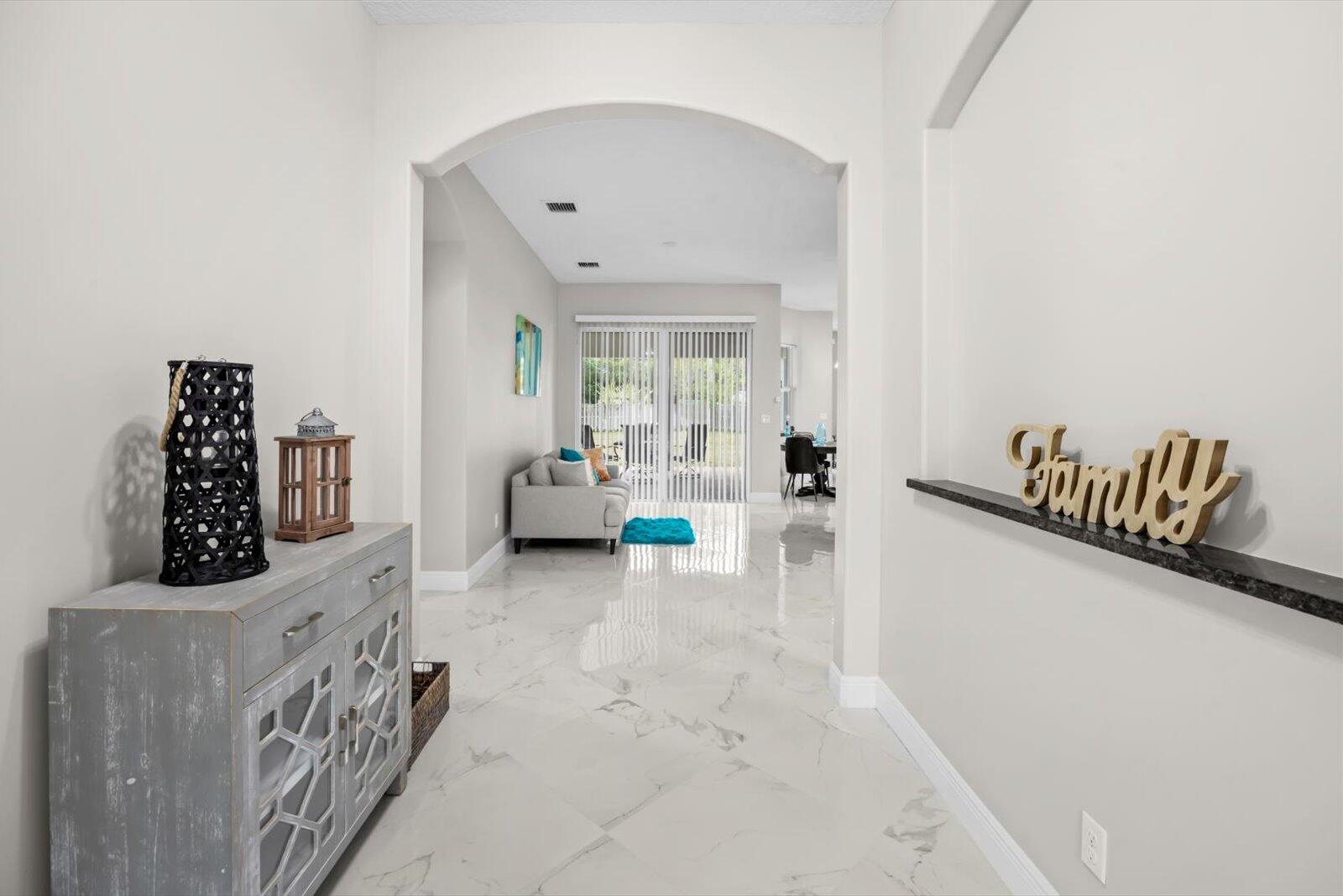 Experience refined Florida living in this elegant 2020 CBS contemporary residence set on a generous 0.29-acre lot in a peaceful Port St. Lucie neighborhood with no HOA. This impeccably maintained single-story home offers 4 bedrooms, 3 baths, and 2,536 sq ft of thoughtfully designed living space with a desirable split-bedroom layout. The open-concept interior features ceramic tile flooring, a chef-inspired kitchen and breakfast area, and expansive living and family spaces ideal for entertaining. The primary suite is a private retreat with dual vanities, a spa tub, and a separate shower. Outdoors, enjoy a fenced backyard with fruit trees, a covered patio, garden views, and ample room for a pool. Enhanced by a metal roof, full panel shutters, a security system, and a 2-car garage.