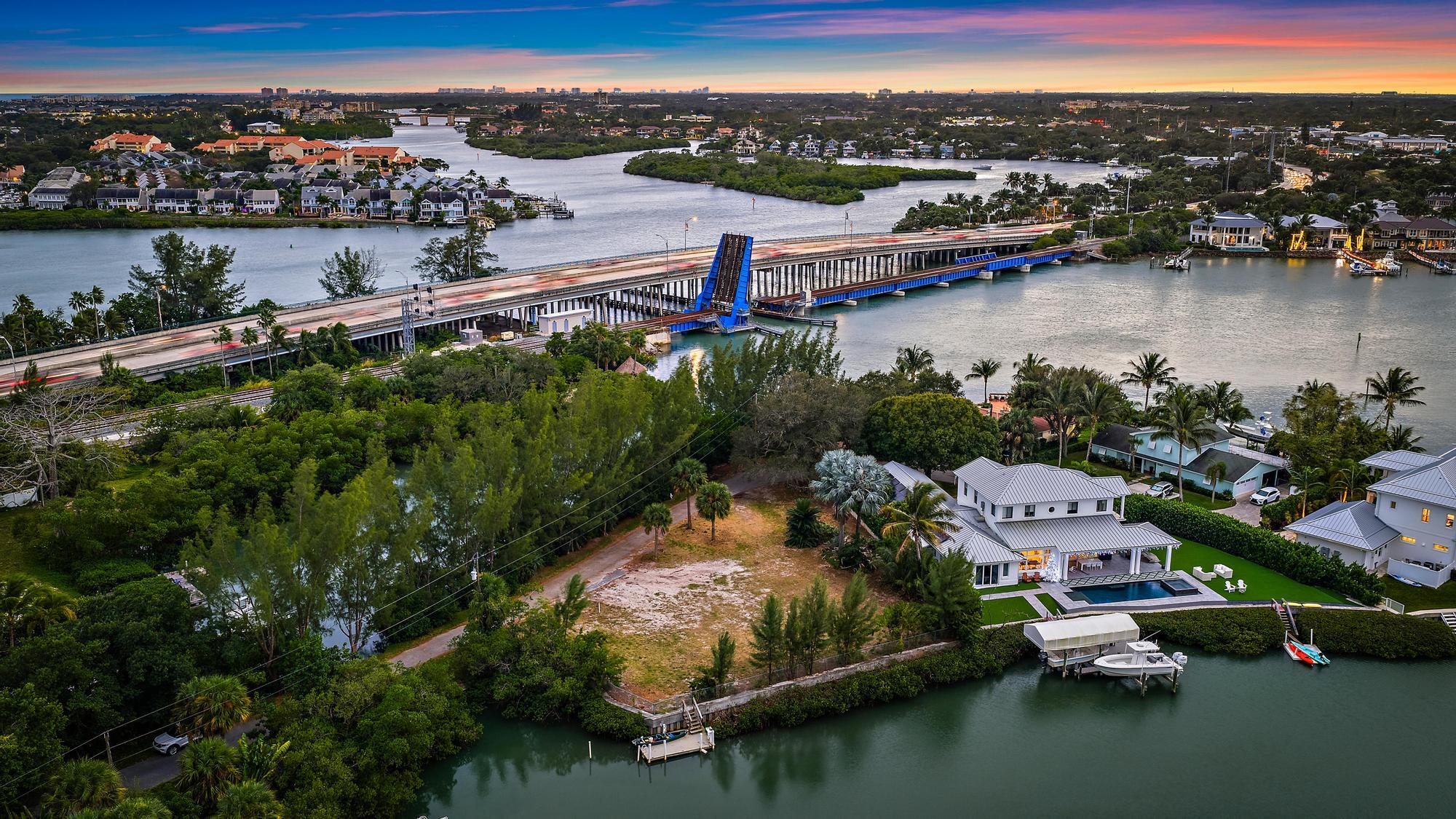 READY TO BUILD WATERFRONT LOT!!! Welcome to one of Jupiter's rarest and most breathtaking waterfront opportunities, a PRIVATE, 0.52 ACRE LOT with 200 feet of sparkling aqua-blue frontage along the coveted Loxahatchee River. Tucked quietly among just five homes on a secluded peninsula, this property is truly one of Jupiter's hidden gems, offering unmatched privacy, panoramic WATER VIEWS, and the kind of natural beauty that even seasoned Jupiter locals stop to admire.
Completely cleared and ready for your DREAM BUILD, this parcel delivers water on three sides, front, side, and rear, creating a one-of-a-kind canvas for a custom waterfront estate. A NEWER SEAWALL wraps the property and the existing BOAT DOCK provides effortless access to the Jupiter Inlet, sandbars, world-class fishing, and the turquoise waterways that define life in South Florida. This lot offers privacy and protection from boat traffic and is minutes to the Jupiter Lighthouse and ocean access. 
Located just a short distance from Jupiter's pristine beaches, iconic waterfront dining, championship golf, and a vibrant lifestyle that blends luxury with laid-back coastal living, this property offers the perfect foundation for an architectural masterpiece. Opportunities like this don't come along often. This is Jupiter waterfront at its most exclusive, most private, and most spectacular.