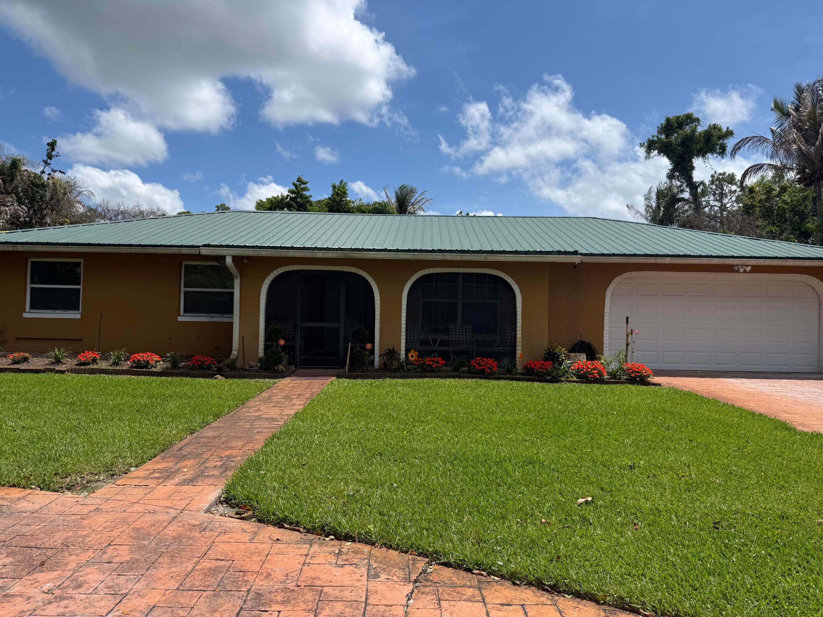 Welcome to this charming 3-bedroom, 2-bath home in Loxahatchee offering both comfort and functionality. This property features a durable tin roof and and large enclosed storage space, a rare combination of city sewer service with well water for irrigation—helping keep utility costs down. Enjoy a spacious, fully fenced yard with a variety of mature fruit trees, perfect for outdoor living or gardening. The circular paved driveway with a gated entrance provides added privacy and ample parking for guests, RVs, or boats. With plenty of room to expand and no HOA restrictions, this home is ideal with a new A/C, water heater, and new appliances in 2025 for those seeking space, flexibility, and a peaceful lifestyle.