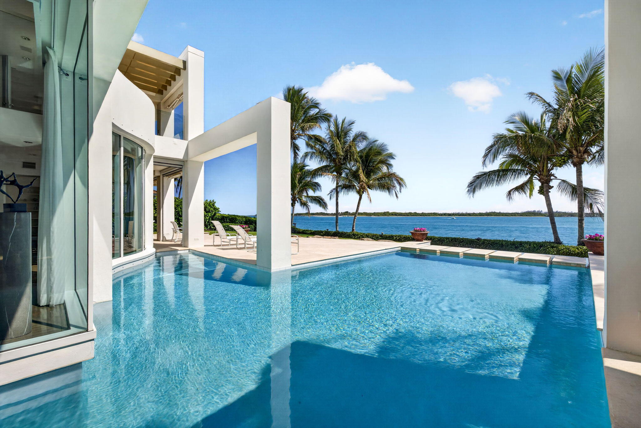Once host to a grand community ball, this exceptional waterfront estate is ready to welcome its next owner. Ideally positioned on the St. Lucie Inlet with sweeping views to the Atlantic Ocean, the breathtaking water vistas are truly unforgettable. This pristine contemporary residence is designed for seamless indoor-outdoor living, featuring soaring ceilings, expansive walls of glass, 4 bedrooms, a den, a dedicated office, and garages for three cars. After a day on the water, unwind in the resort-style pool and spa, relax on one of the multiple terraces, or enjoy spectacular sunsets from your private day-dock. Additional highlights include a 60 KW generator, 50-amp EV service, elevator, impact glass, and armor screens. Located within the exclusive community of Sailfish Point, residents  enjoy an oceanfront clubhouse, five dining venues, a fitness and aquatics complex, full-service marina, spa, optional golf on the Jack Nicklaus Signature Golf Course, and exceptional private security