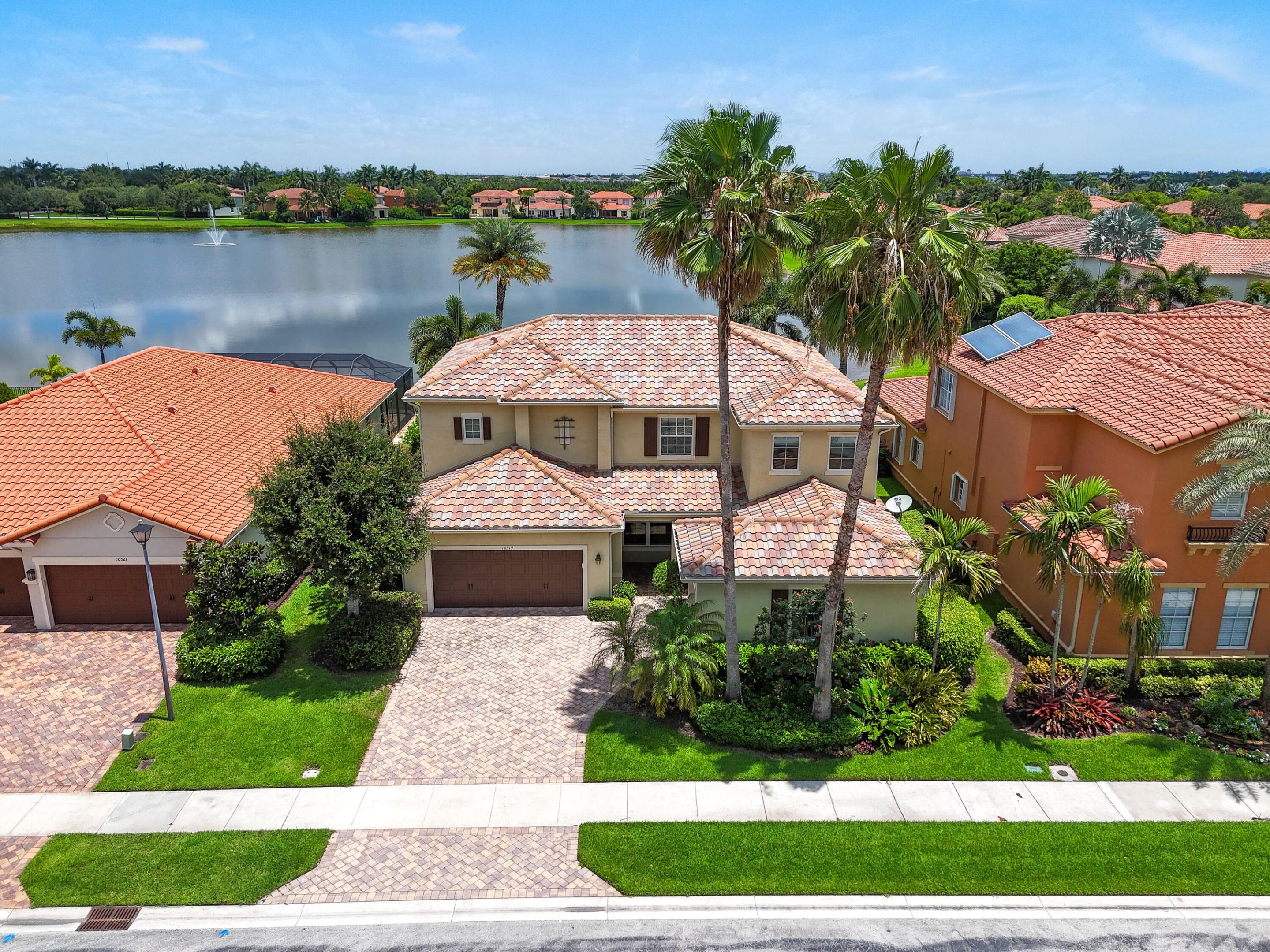 Enjoy peaceful lake views and an exceptional South Florida lifestyle from this beautifully maintained residence in the highly sought-after gated community of Oakmont Estates. Thoughtfully designed for both everyday living and entertaining, this impressive home features impact windows and doors, a rare three-car garage, and four full bathrooms.  Step inside to soaring ceilings and an elegant wrought-iron staircase that creates a striking focal point in the grand two-story living room. The formal dining room offers the perfect setting for family gatherings and special occasions. At the heart of the home, the spacious kitchen is designed to impress, featuring a massive center island, stainless steel appliances, granite countertops, a stylish new tile backsplash, abundant cabinetry,  a snack bar, and an expansive breakfast nook overlooking the pool and tranquil lake views. The open-concept family room seamlessly connects to the kitchen and outdoor living spaces through French doors, creating an ideal flow for indoor-outdoor entertaining. A highly desirable first-floor guest suite and full cabana bath provide privacy and convenience for visitors.  Upstairs, the spacious primary suite serves as a private retreat, complete with a spa-inspired bathroom and an oversized walk-in closet. Additional accommodations include two bedrooms connected by a Jack-and-Jill bath, an additional en-suite bedroom, and a conveniently located upstairs laundry room.  Outside, enjoy your own private backyard oasis featuring a saltwater pool with a sun shelf and decorative fountains, all set against a serene lake backdrop. Relax under the covered screened patio or entertain guests poolside while enjoying the peaceful setting of this premium location tucked away in a quiet corner of the community.  Residents of Oakmont Estates enjoy an exceptional lifestyle with amenities that include a virtually manned security gate, front and rear lawn maintenance, ADT alarm monitoring, a resort-style clubhouse, community pool, fitness center, tennis courts, and a children's playground.  Ideally located within Wellington's top-rated school district and just minutes from shopping, dining, world-renowned equestrian venues, Palm Beach International Airport, beautiful beaches, and the vibrant downtown districts of West Palm Beach, Lake Worth Beach, and Delray Beach.