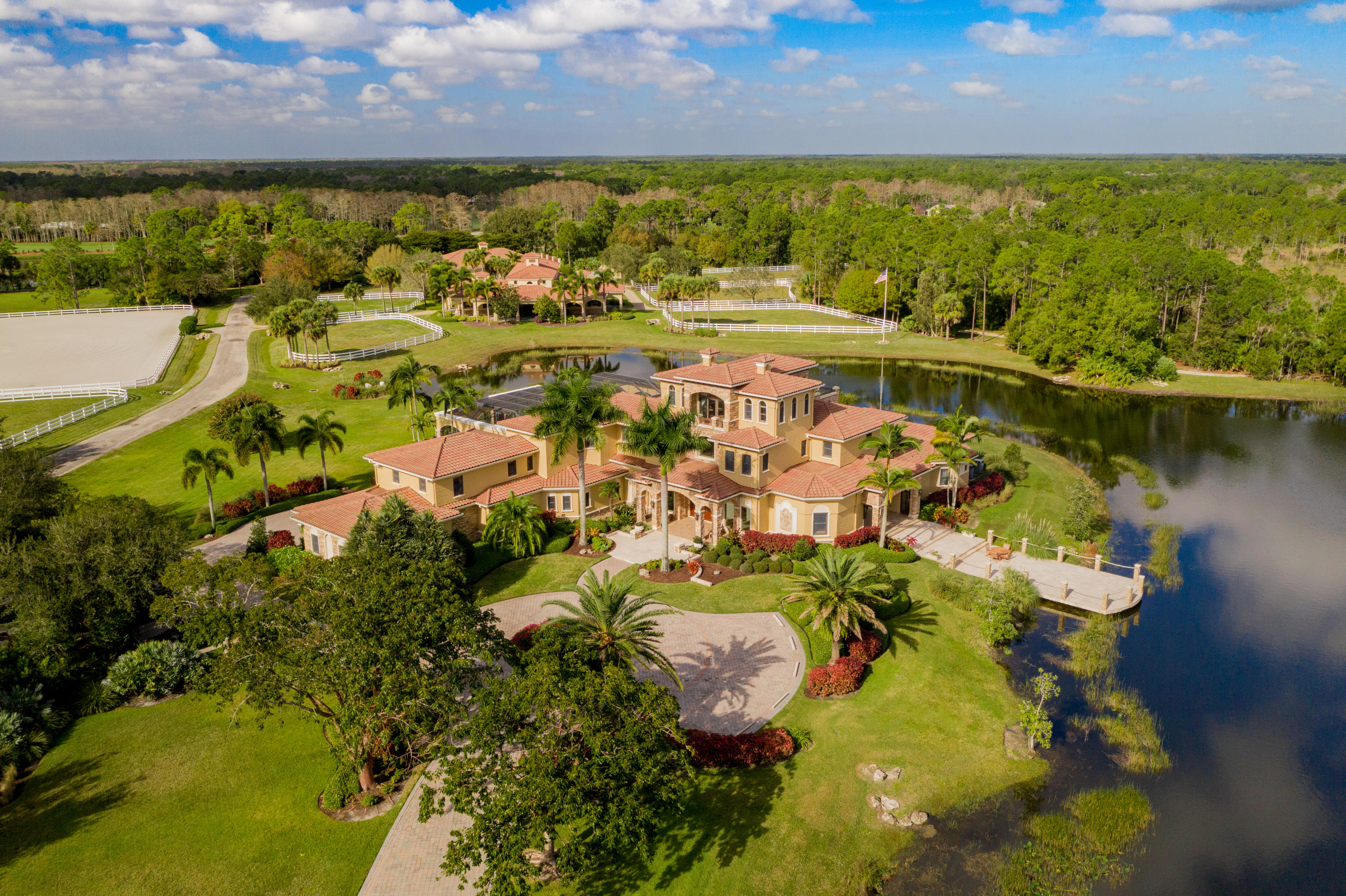 Bidding NOW OPEN through Tuesday April 13th.  There is still time to register.  

Re-imagine luxury living with this impeccable 30-acre property and the immaculate lifestyle it offers, or combine the adjacent 20-acre parcel for an unheard of 50-acre exceptional South Florida estate. Tucked into the exquisite gated community of Ranch Colony, no feature or comfort was spared in the careful construction of this sprawling Mediterranean-style paradise. Old-world ambiance and classical details are perfectly paired with modern convenience and technology for ultimate luxury. Indoor-outdoor entertaining has never been easier than within its spacious alfresco living areas, like the first floor great room with retractable screen loggia opening to a pier on the property's private four-acre fishing lake. Look out at the sprawling acreage from the third-floor observation lounge with its massive covered deck, balcony, and full bar. The fully-fitted main kitchen, second chef's kitchen, and summer kitchen offer flexible options for entertaining. Wade into the spectacular heated salt-water pool, sip drinks at the poolside indoor-outdoor bar, or wander the lush gardens and emerald grass down to the guest house or highly adaptable barn structure. This property allows for great versatility. The stable can easily be converted into a second home or a common recreation/theater/entertainment center supporting additional custom homes on open land while maintaining privacy, the ultimate family compound.  This structure would also make a great studio for art, music, and other forms of entertainment. For the auto enthusiast, due to the structural expansion capability, these facilities could easily be converted into showroom space housing 25 vehicles or more with generous shop and restoration space.

Additional highlights of the five-bedroom home include a dining room, a family and billiards room, a 1,000-bottle wine cellar, a luxurious ground-level master suite, and a lounge and terrace enjoying sweeping views of the property.  Home and main buildings are built at an elevation to eliminate flood risk with the highest hurricane impact construction standards exceeding Miami/Dade Hurricane Codes. Concrete and rebar poured roof and floor systems plus two commercial diesel generators provide for a safe, self-contained and secured property. This unique construction is found in less than 1% of the residential homes in Florida and represents a SUBSTANTIAL value versus replacement costs.  Ranch Colony is surrounded by nature preserves spanning more than 20,000 acres, affording access to parks and horseback riding trails. It could accommodate a variety of activities and pursuits, e.g. space for tennis courts.  Superior golfing is steps away at the world-renowned Dye Preserve, which adjoins the property to the west. Restaurants, shops, theater, and other cultural attractions of Palm Beach, Jupiter, Palm Beach Gardens, PGA, West Palm Beach and Palm Beach International Airport as well as the diverse equestrian and social activities of Wellington are nearby.