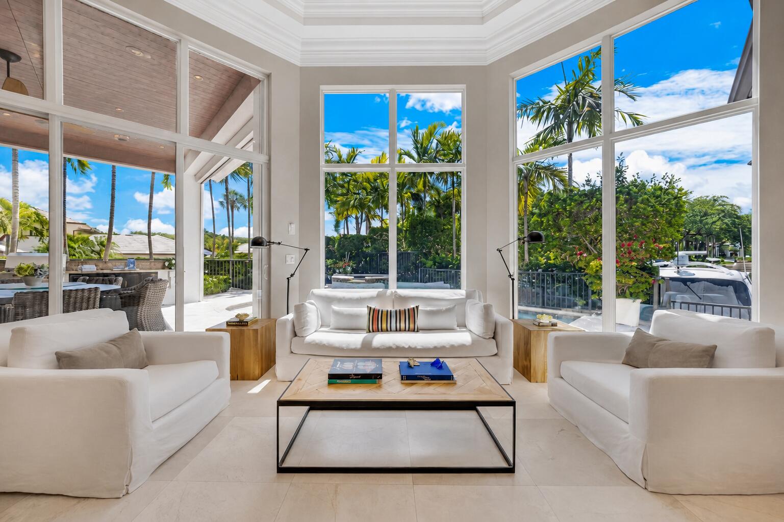 Attention boating enthusiasts! Welcome to this exceptional waterfront residence in the exclusive gated Boca Marina Yacht Club, recognized as one of the community's most prestigious homes.  Built in 2013, this state-of-the-art custom residence offers 4 bedroom suites, 5 full bathrooms, 1 half bath, and 4,276 square feet of refined living space designed for luxury, comfort, and entertaining.  Positioned on a prime corner lot, the home offers exceptional privacy and a unique sense of exclusivity. The private dock accommodates vessels up to 50 feet and is ideally located at the end of a quiet canal basin, offering calmer waters and secure dockage. Highlights include a tidal-adaptive docking system, direct boat fueling from the dock by truck, and direct ocean access with no fixed bridges.   Designed for true South Florida living, the resort-style outdoor area features a heated pool, spa, and steam mist cooling system, along with a beautifully appointed summer kitchen with a wood-paneled ceiling, automatic screens, and auto-controlled blinds.  Other notable features include a cooled 2-car garage with EV charger, whole-house generator, and natural gas.  Residents enjoy private dock access, with HOA maintenance of seawall and docks, adding convenience and peace of mind for boat owners. Boca Marina offers 24-hour manned security, tennis, pickleball, bocce ball, clubhouse, heated pool, and playground.